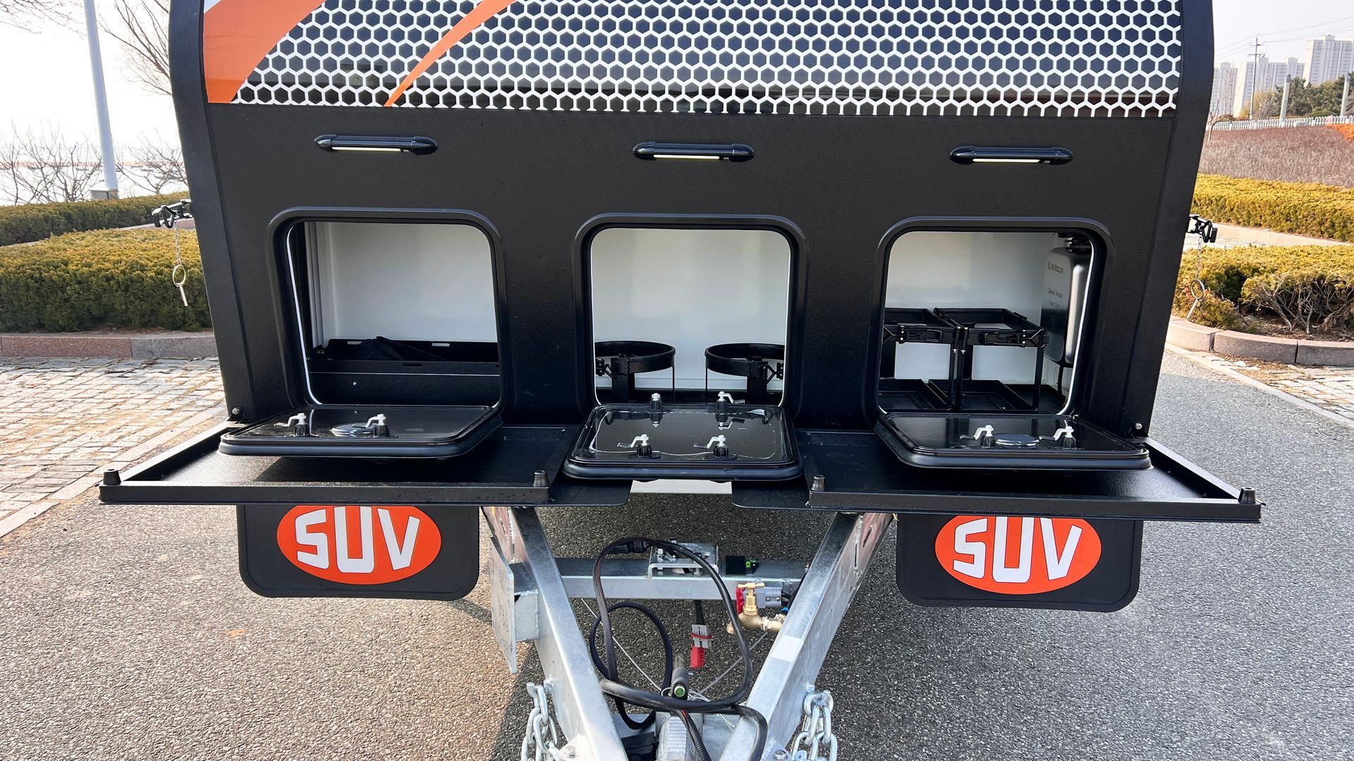 The back of a suv trailer with the doors open.