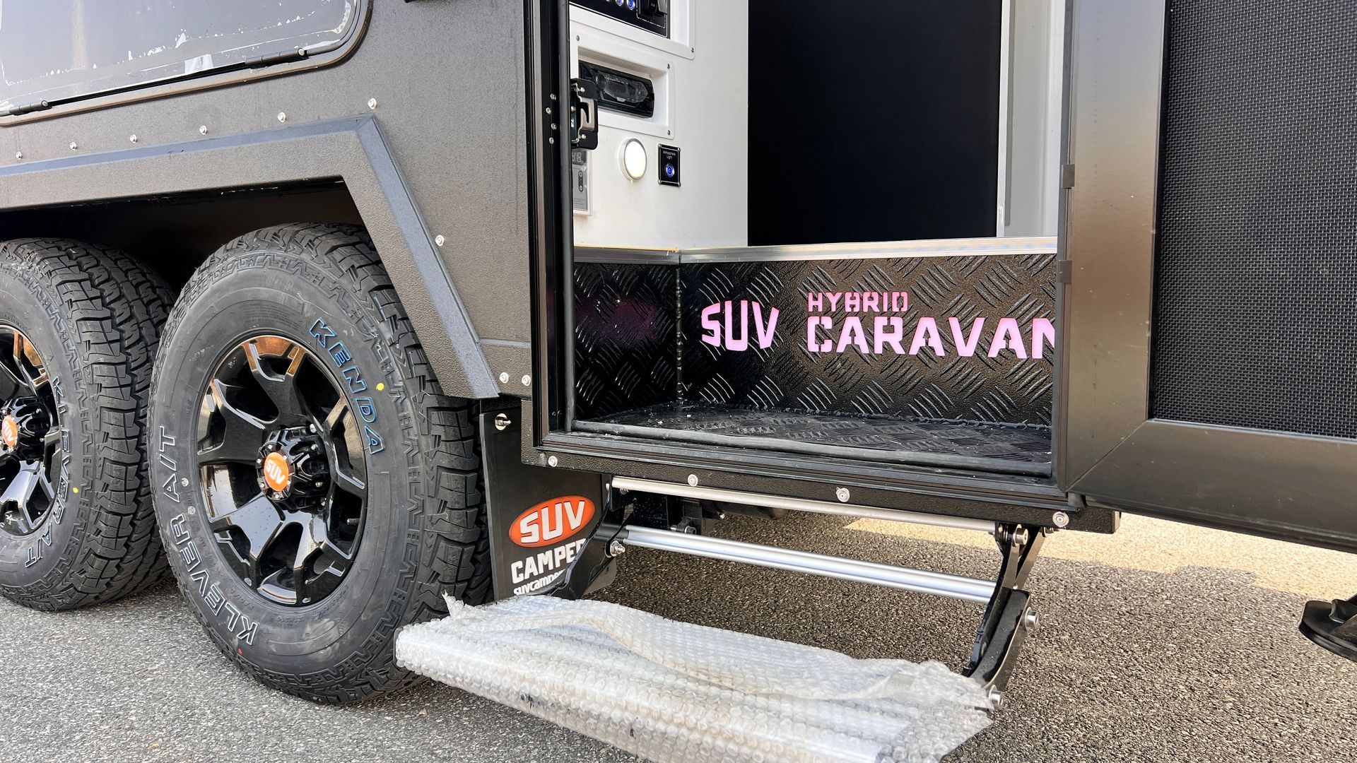 A black suv caravan is parked on the side of the road.