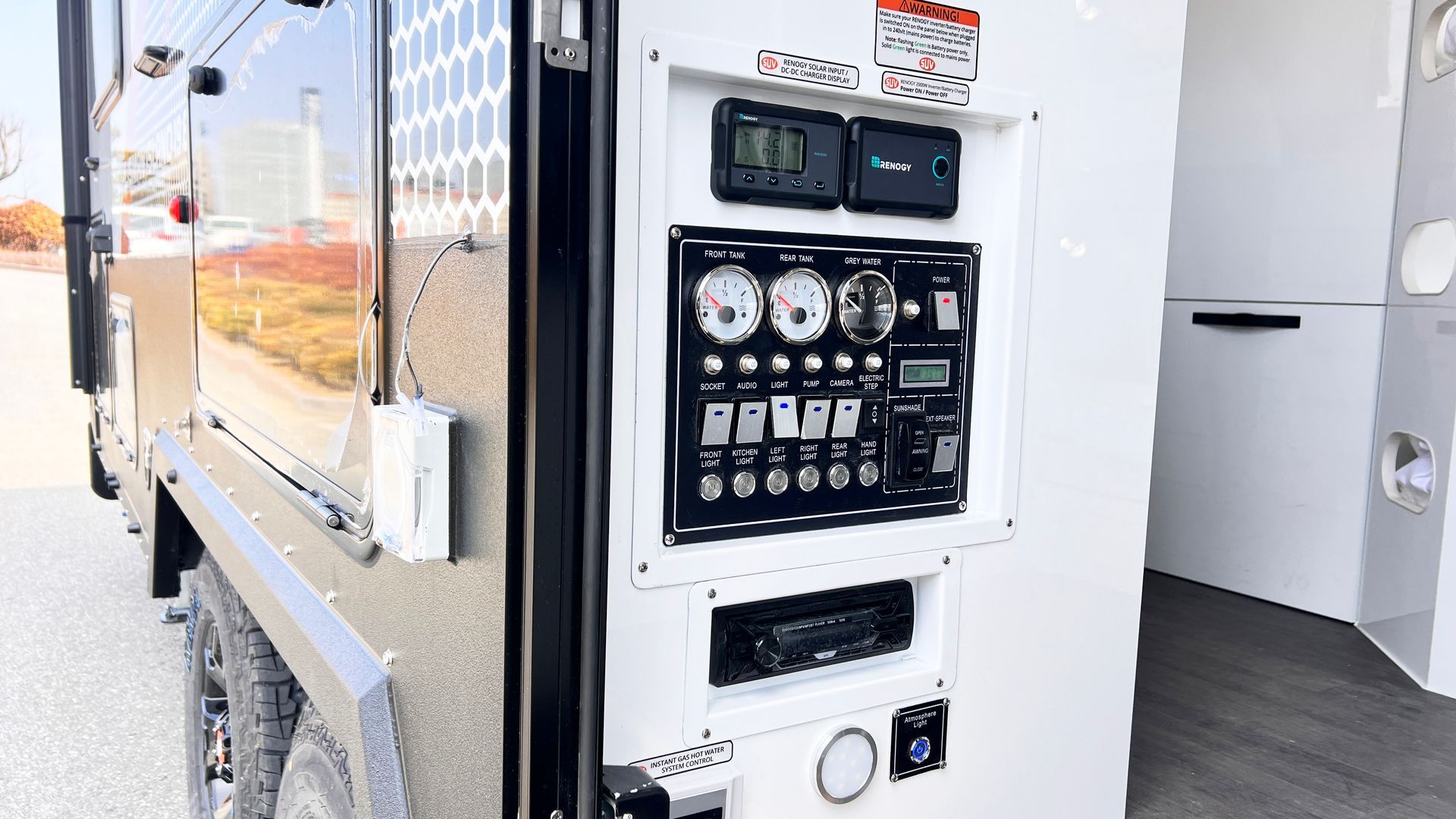 A rv with a lot of electrical panels on the side of it.
