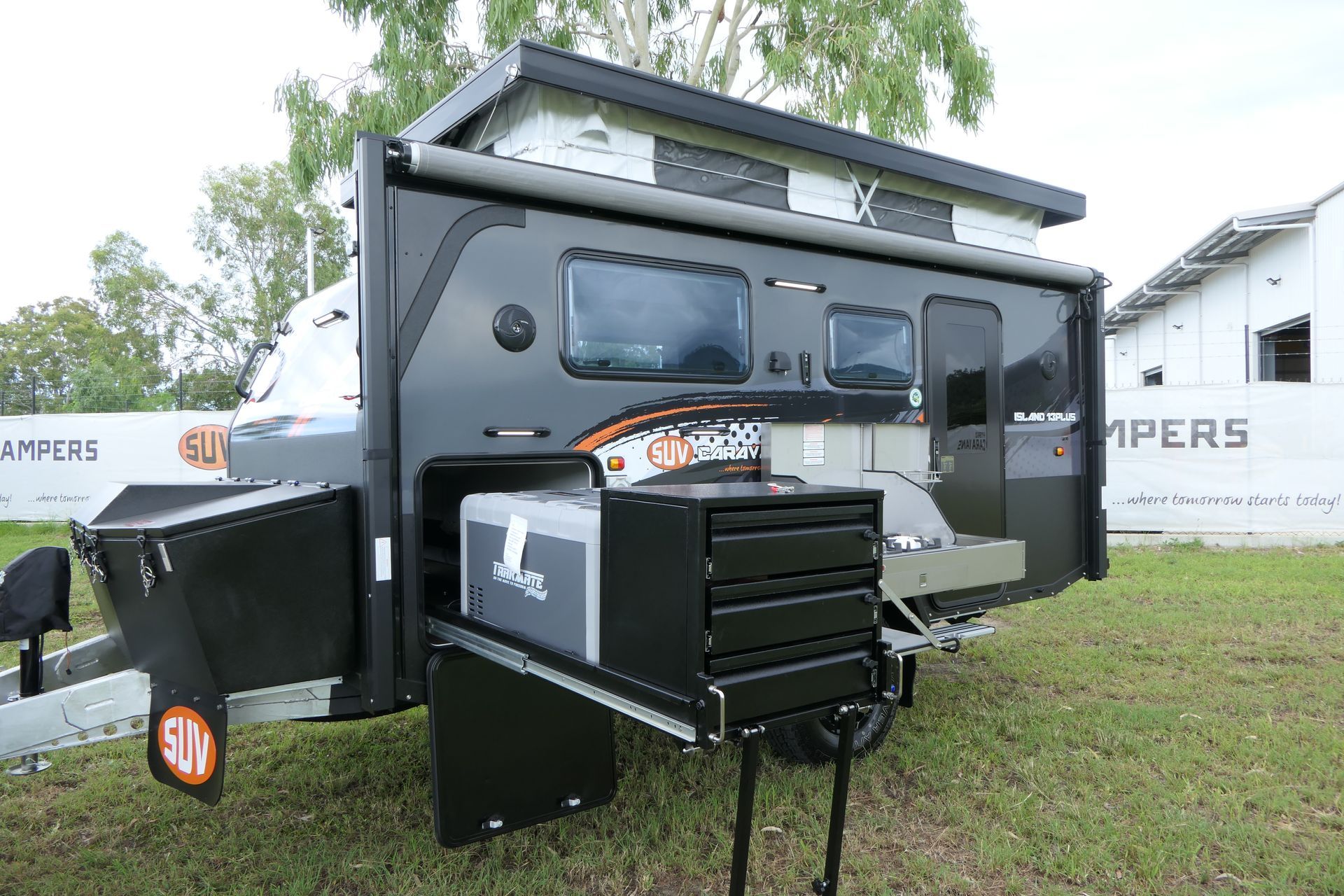 A camper trailer is parked in a grassy field.