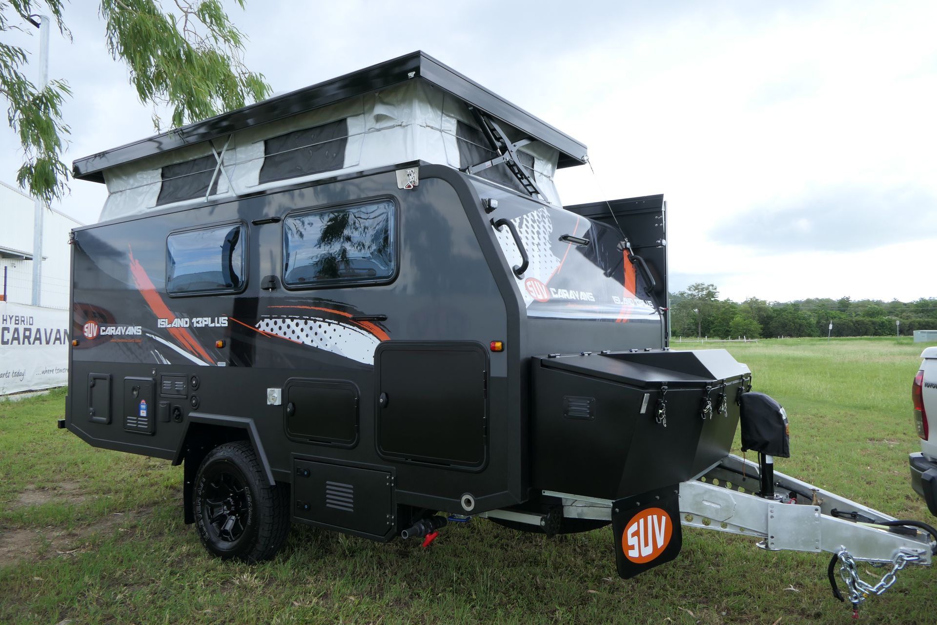 A camper trailer is parked in a grassy field.