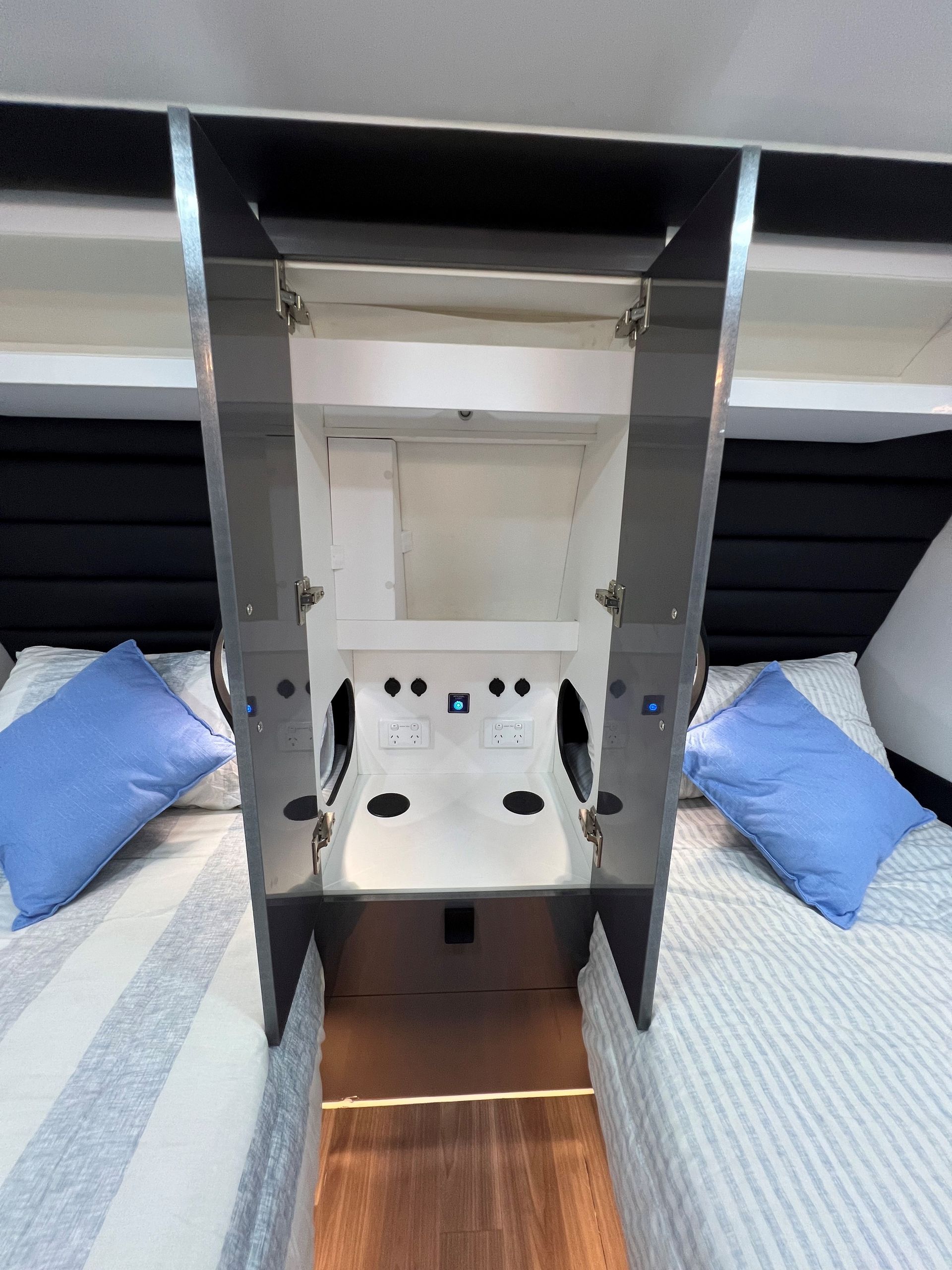 A bedroom with two beds and a cabinet with the doors open