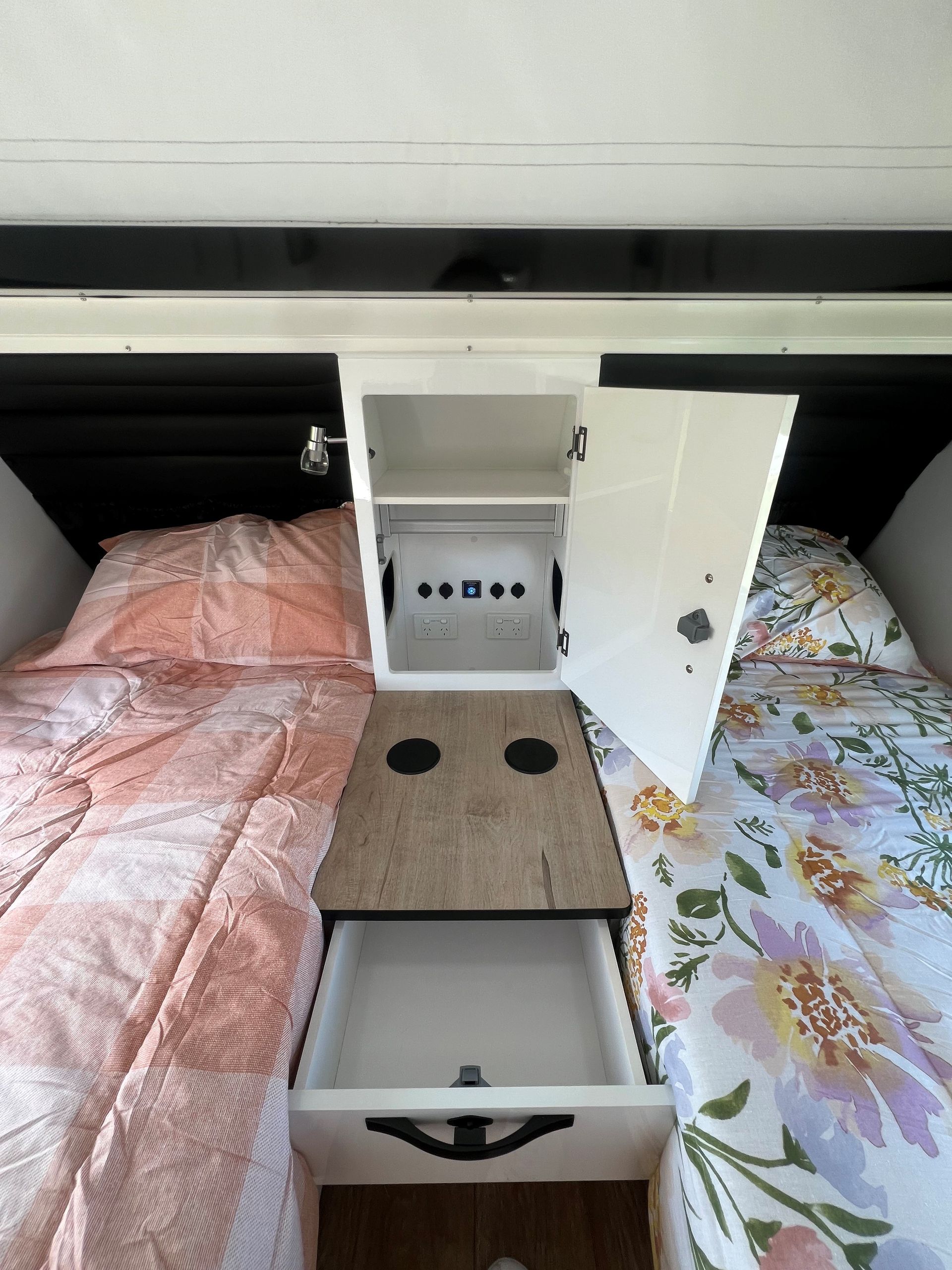 A bed with a table and drawers underneath it.