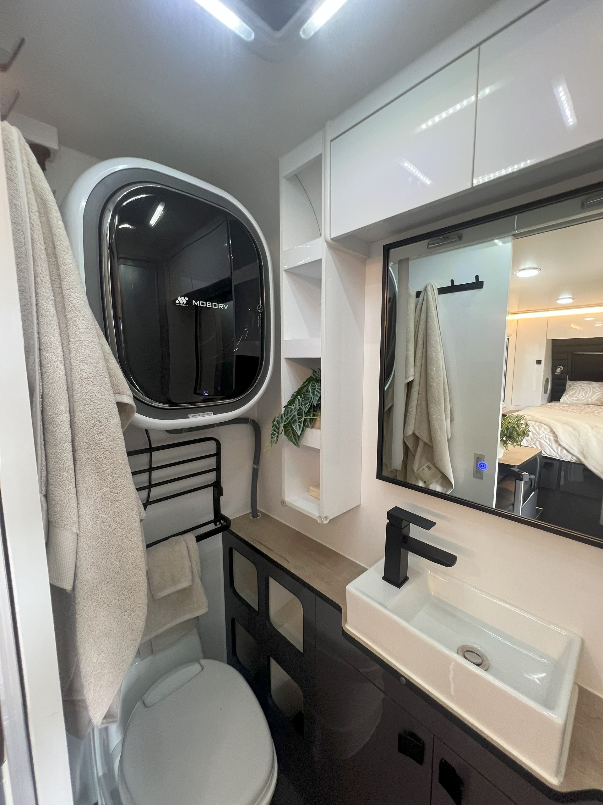 A bathroom with a toilet , sink and mirror.