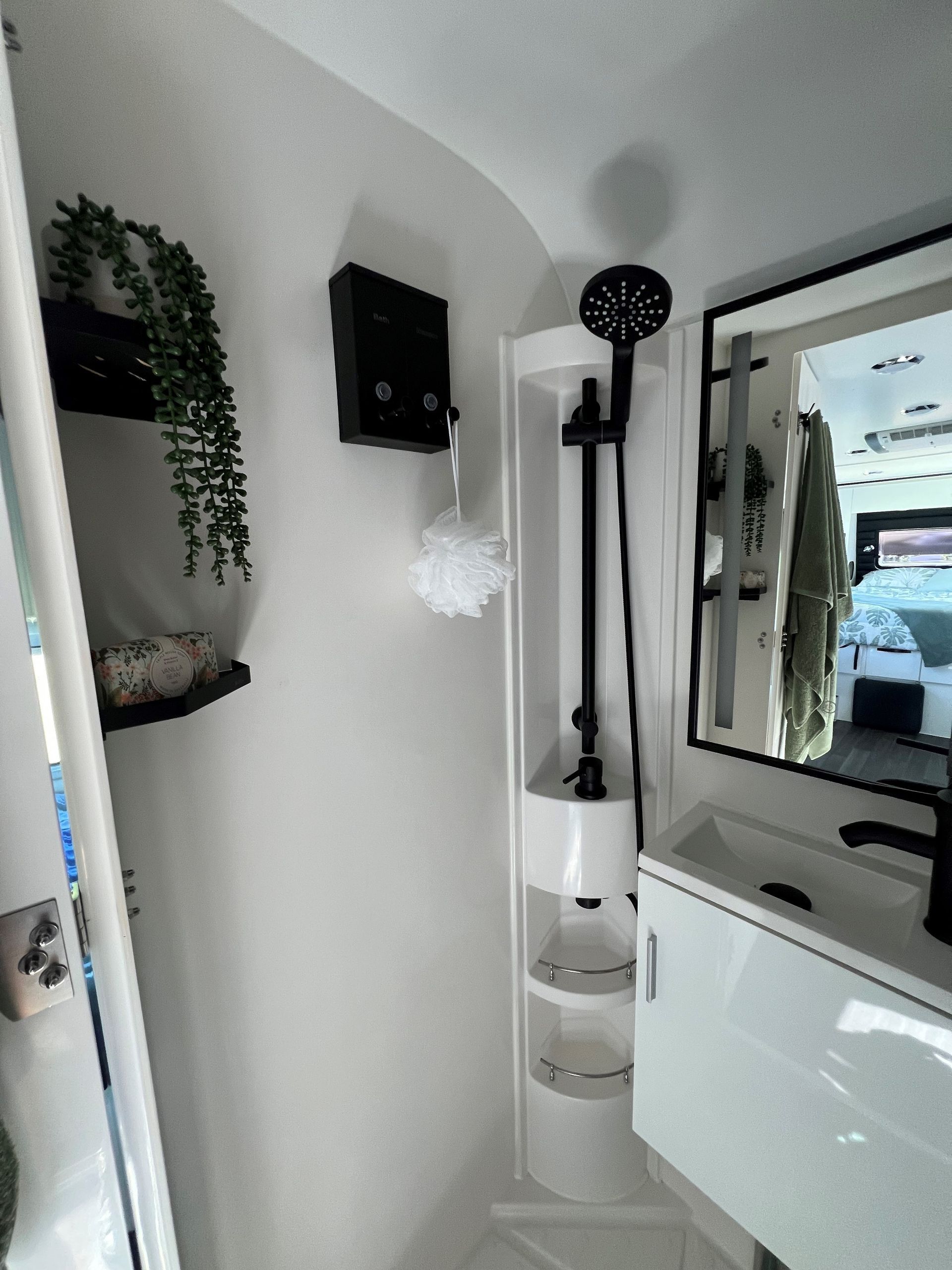 A bathroom with a sink , mirror and shower.