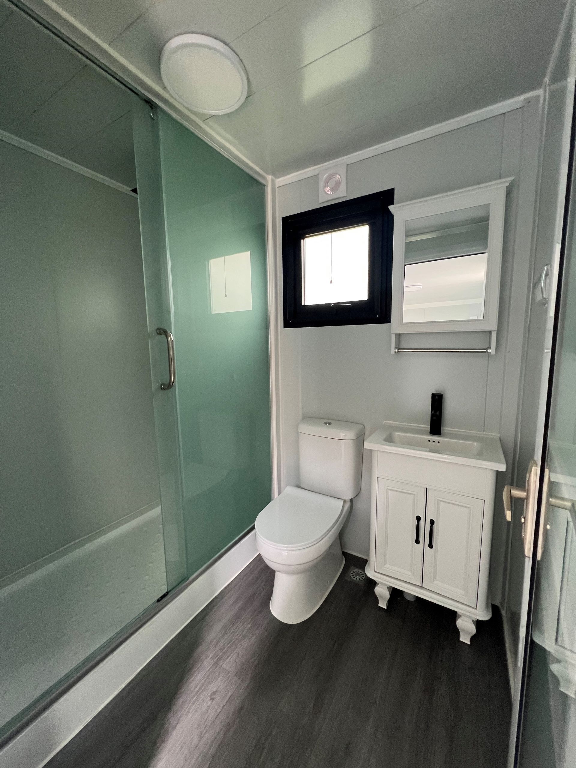 A bathroom with a toilet a sink and a window