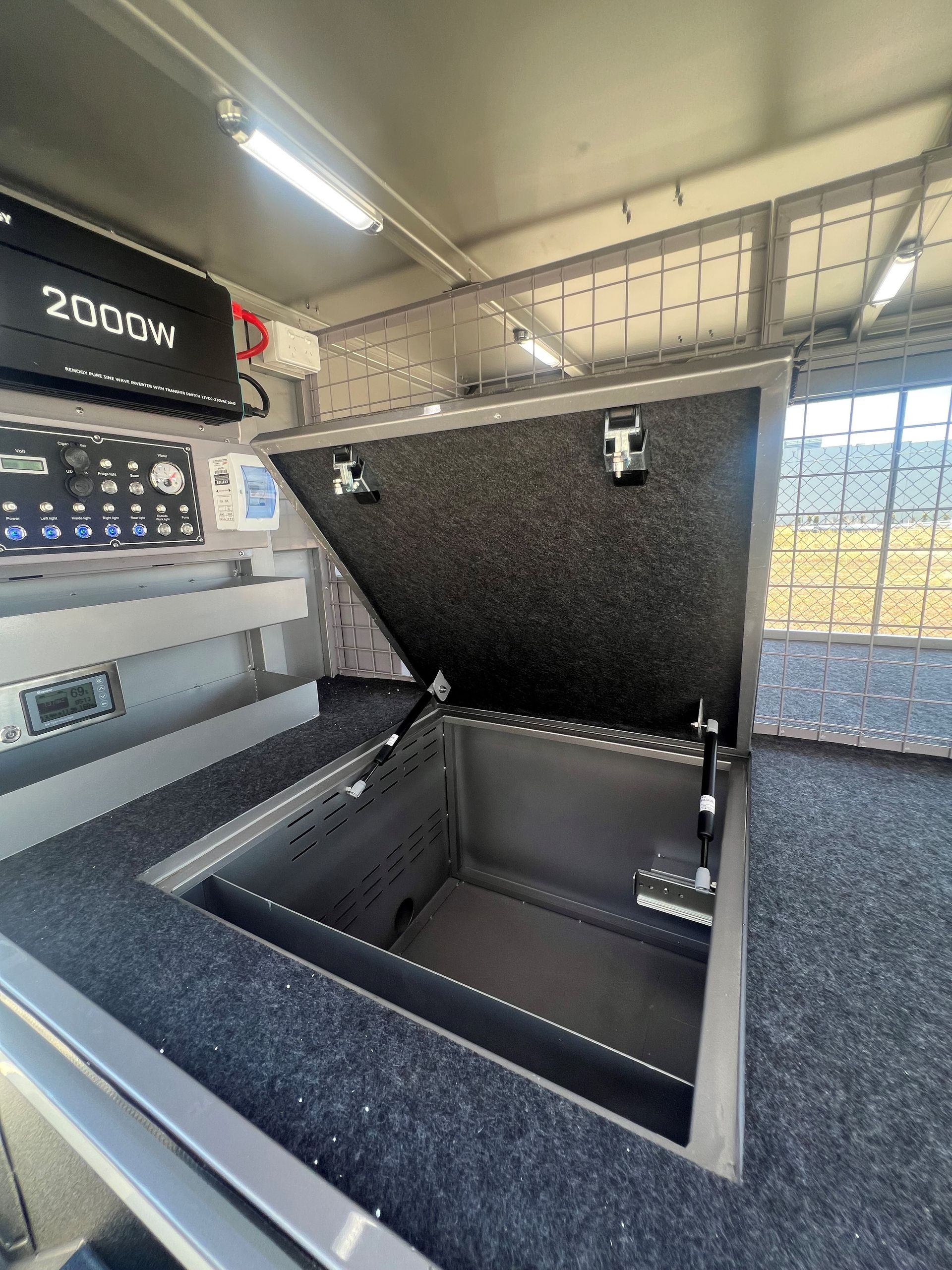 A stainless steel box with the lid open is sitting on top of a counter.