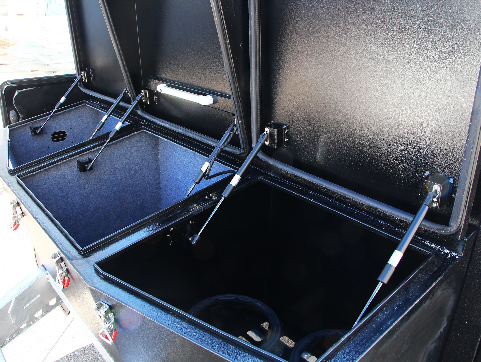 A black metal container with the lid open