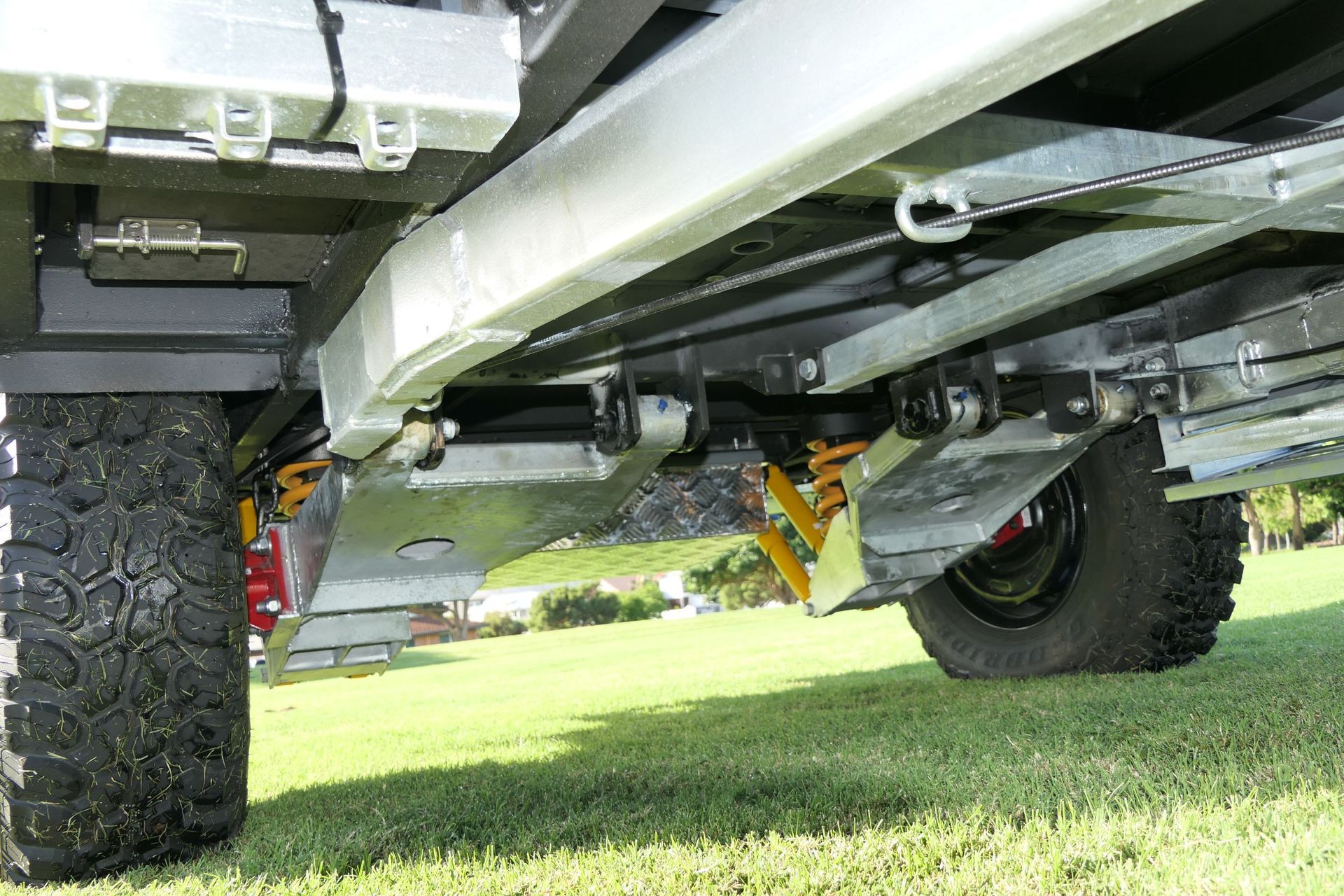 A close up of the underside of a vehicle on a grassy field.