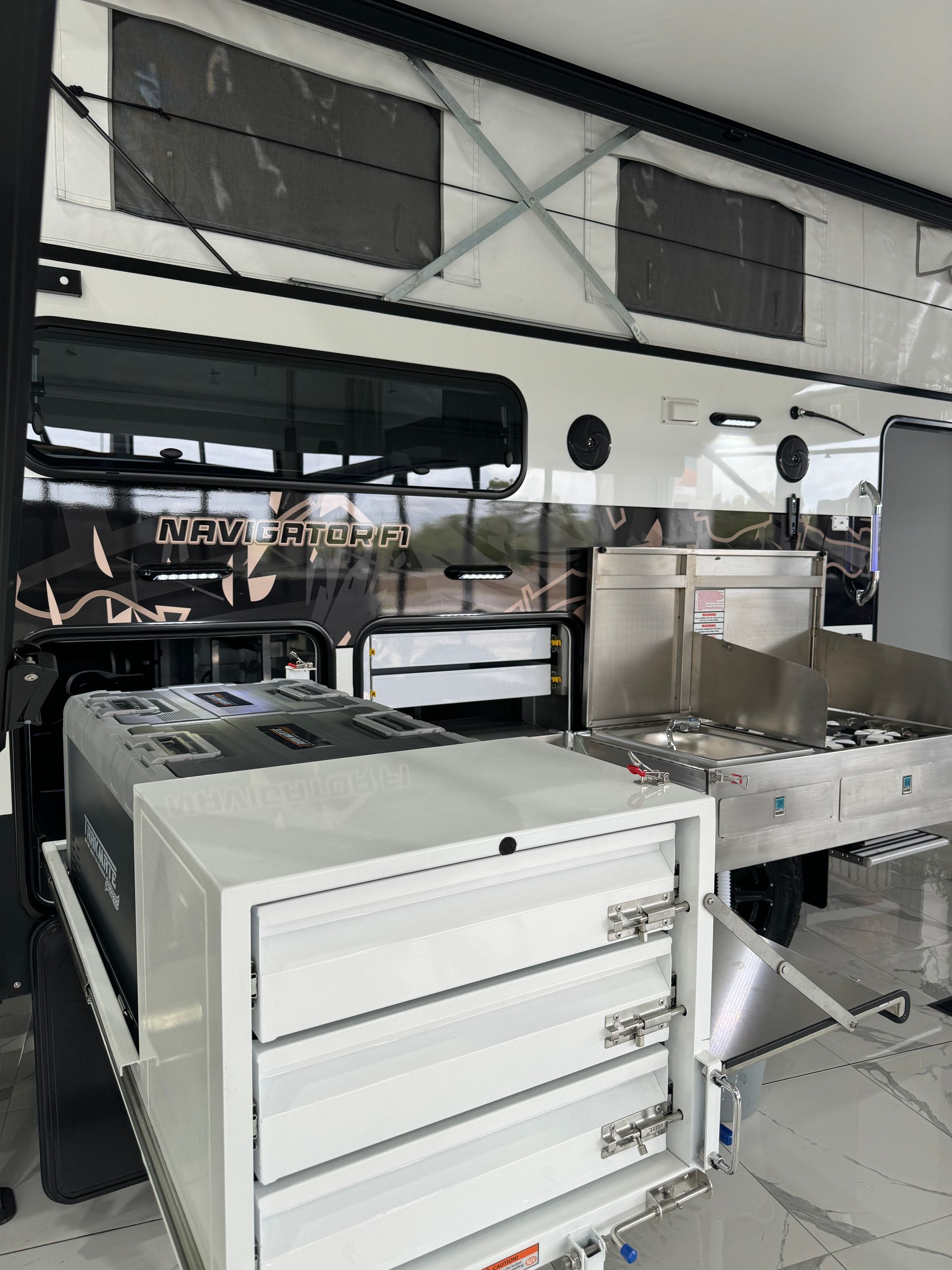 The inside of a camper van with a stove and a refrigerator.
