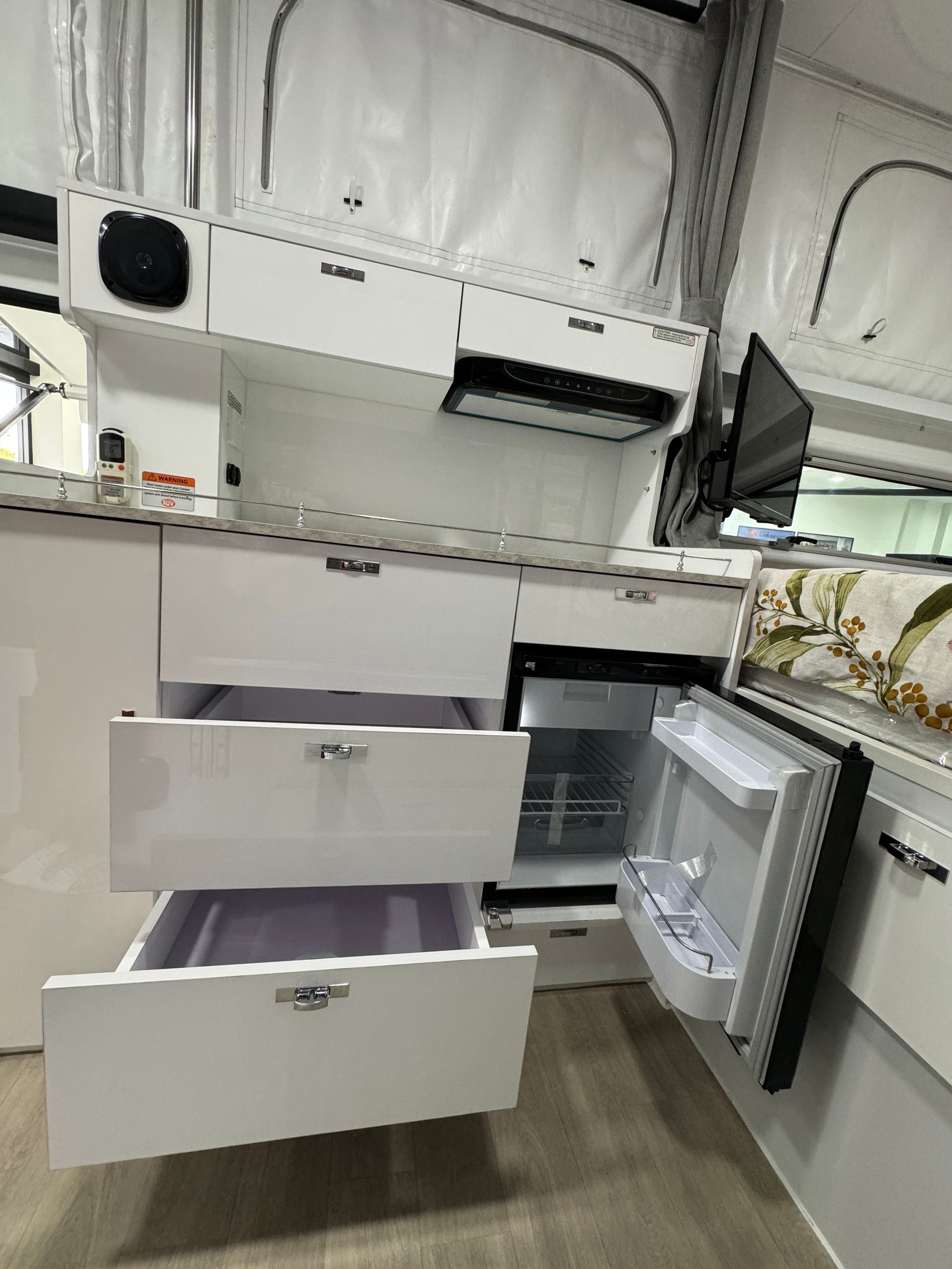 A kitchen with drawers and a refrigerator in it.
