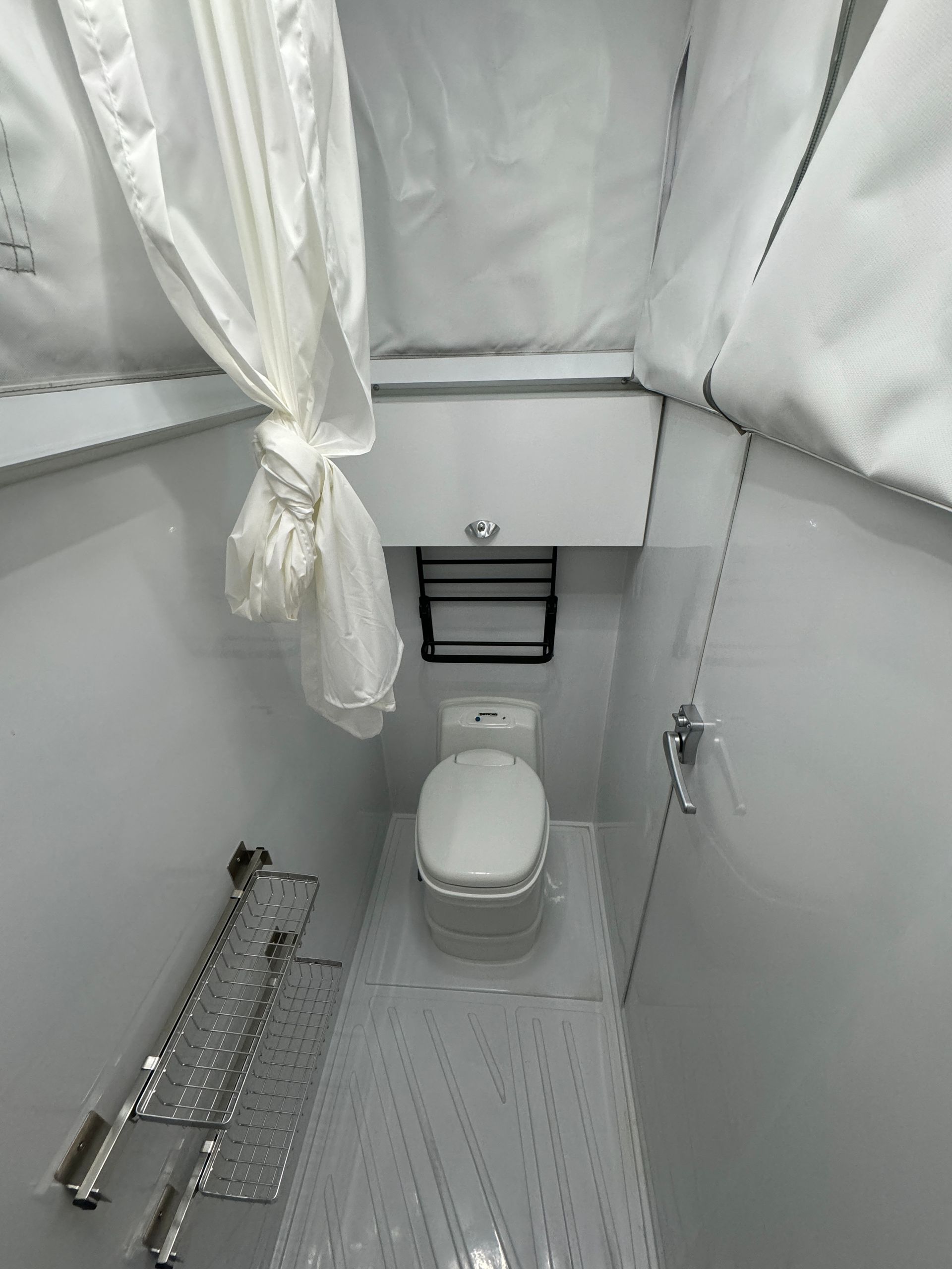 A bathroom with a toilet and a shower curtain.