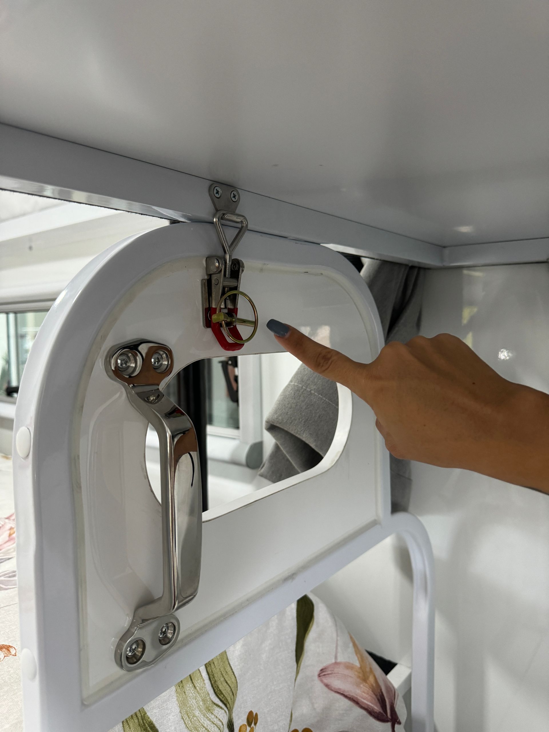 A woman 's hand is reaching for a handle on a white table.