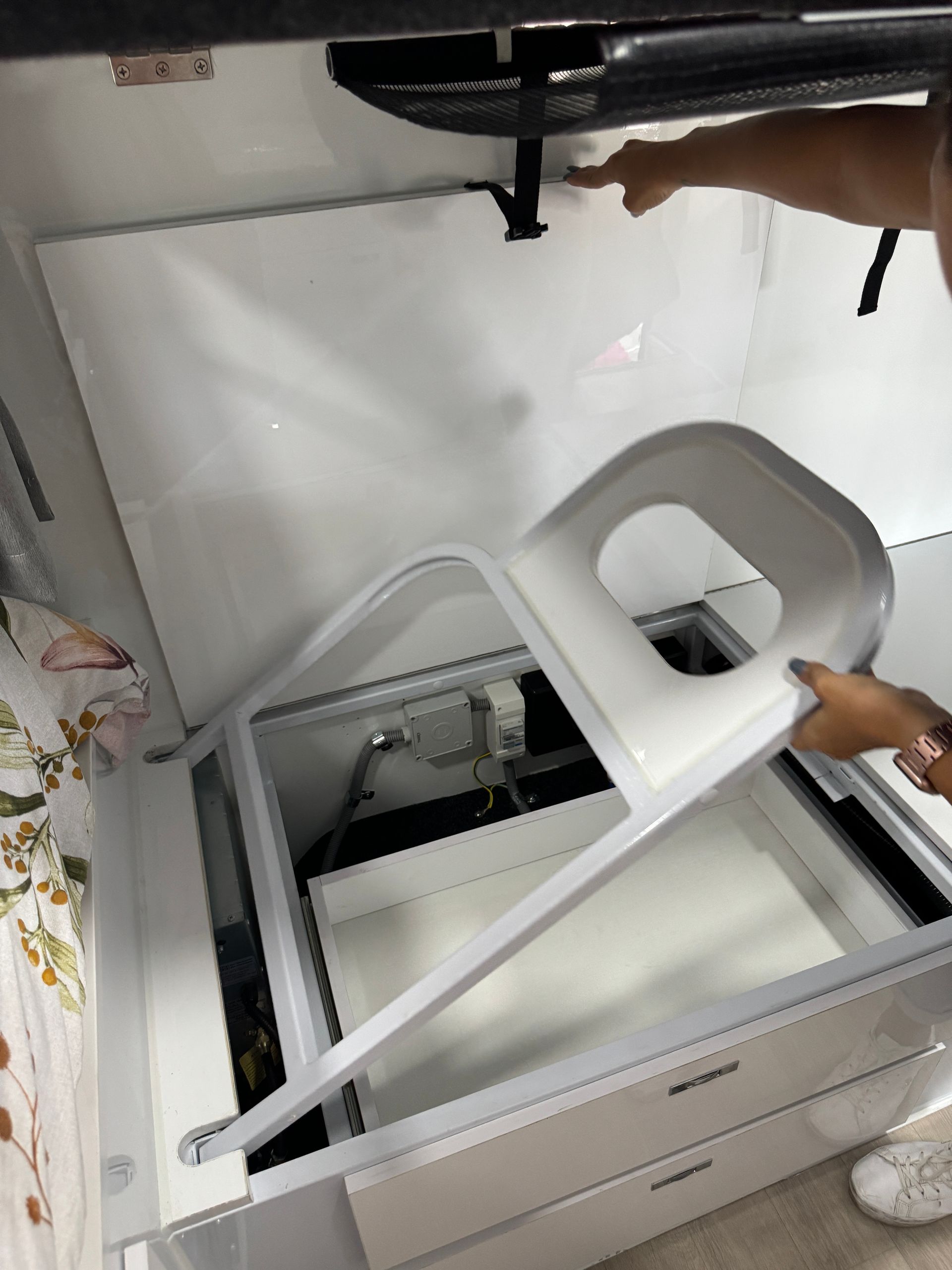 A person is taking a chair out of a refrigerator.