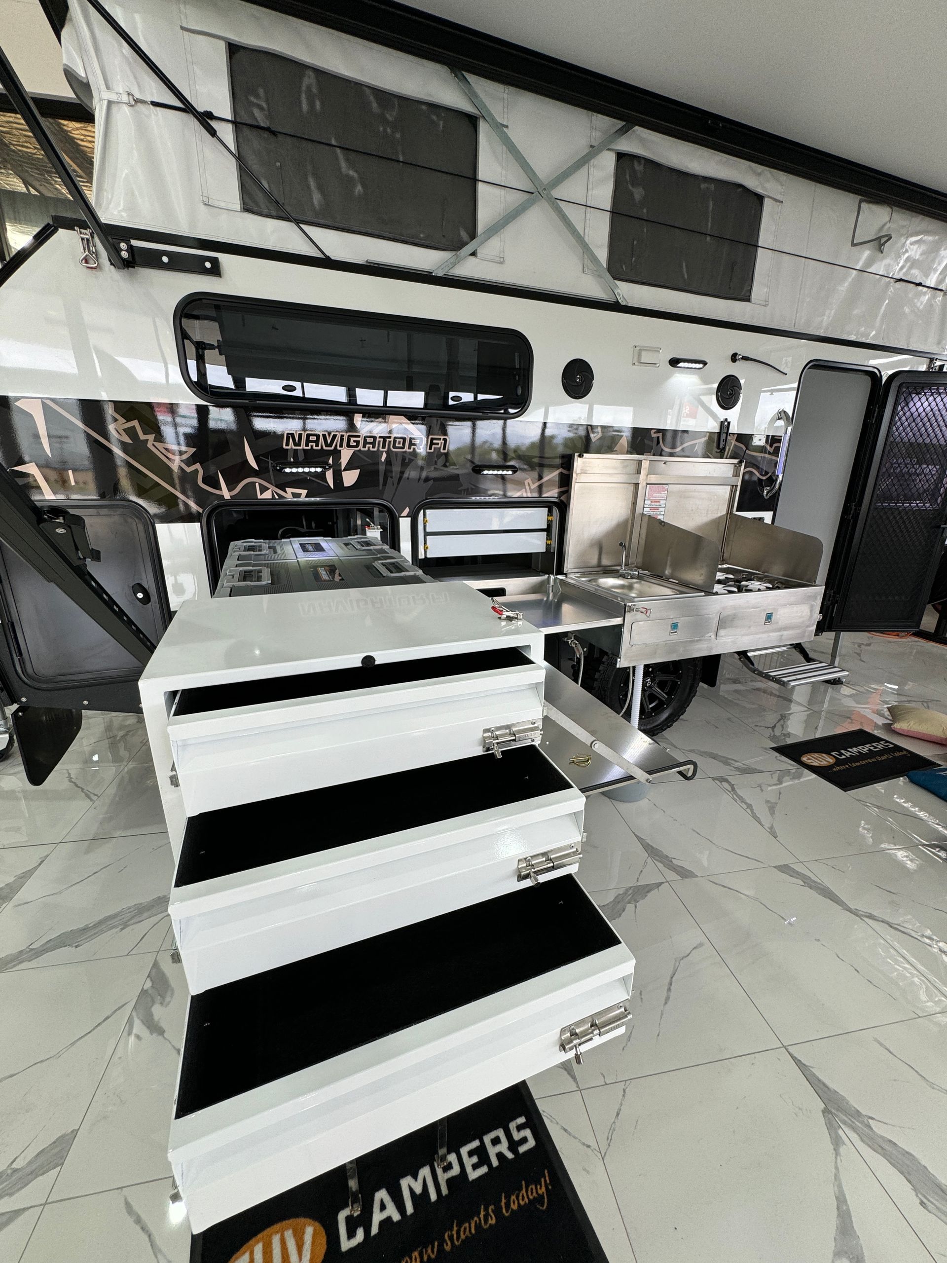 A camper is sitting on top of a marble floor in a showroom.