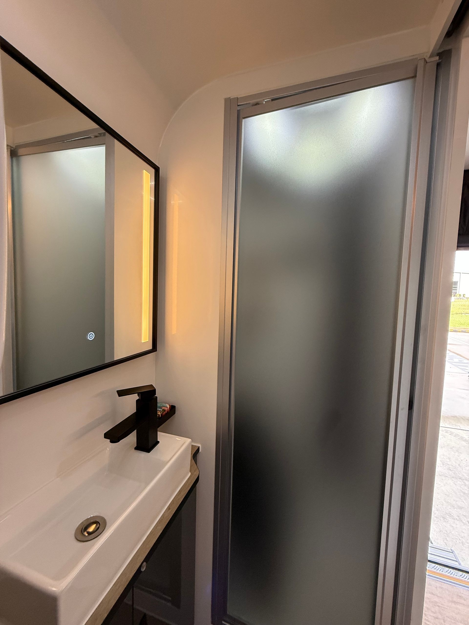 A bathroom with a sink , mirror , and shower.