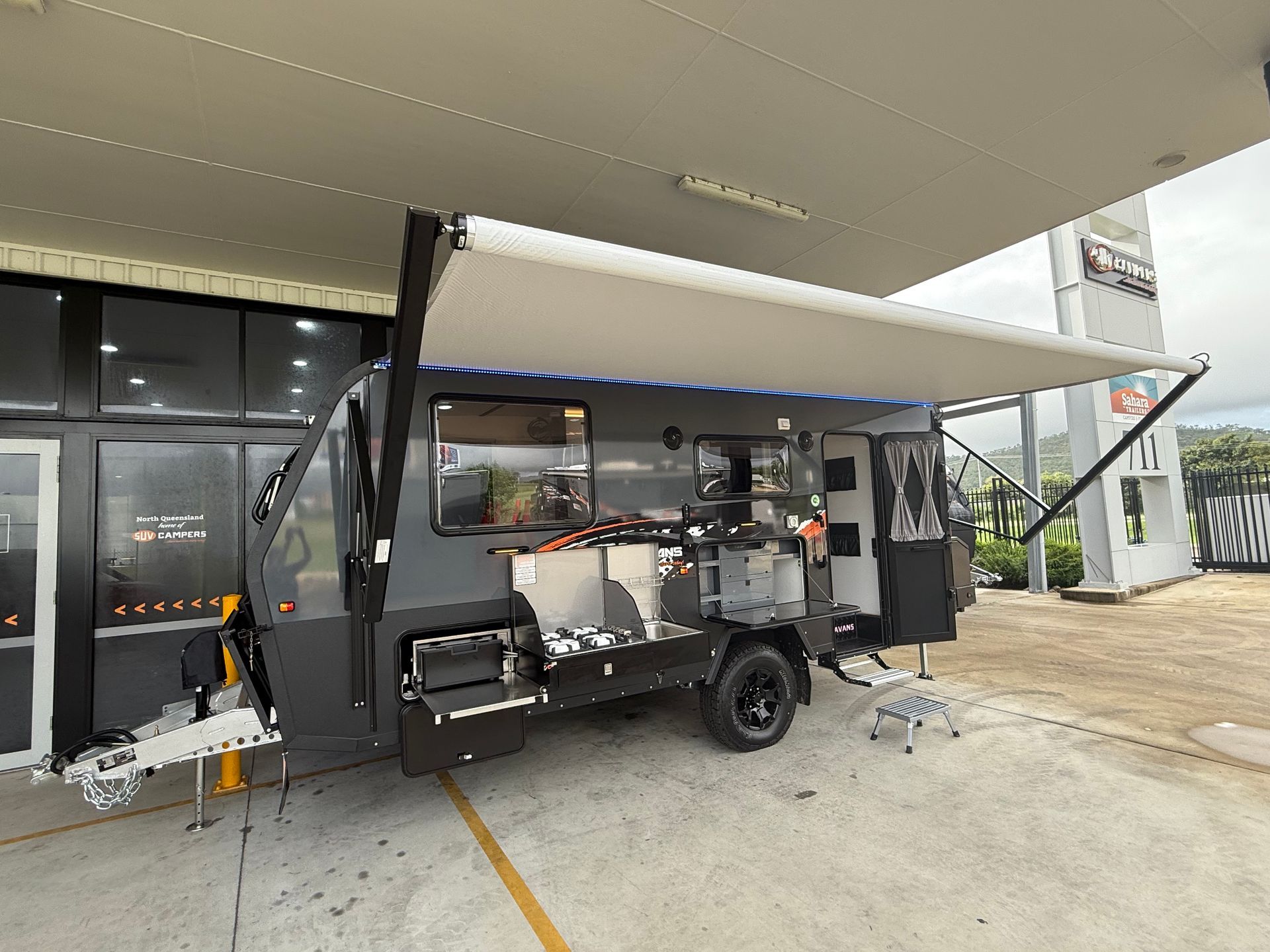A trailer with a canopy is parked in a warehouse.