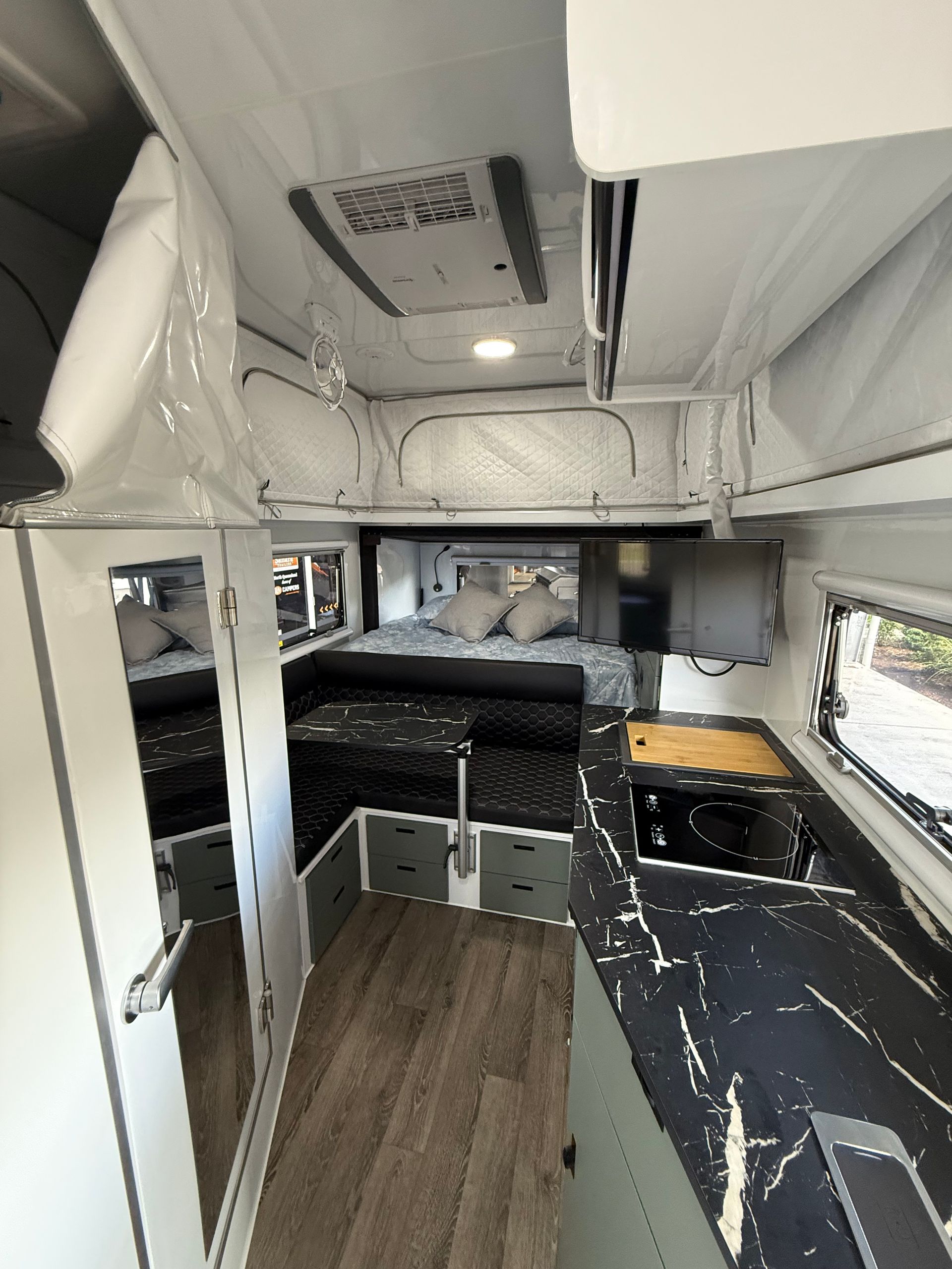 The inside of a camper with a bed and a kitchen.