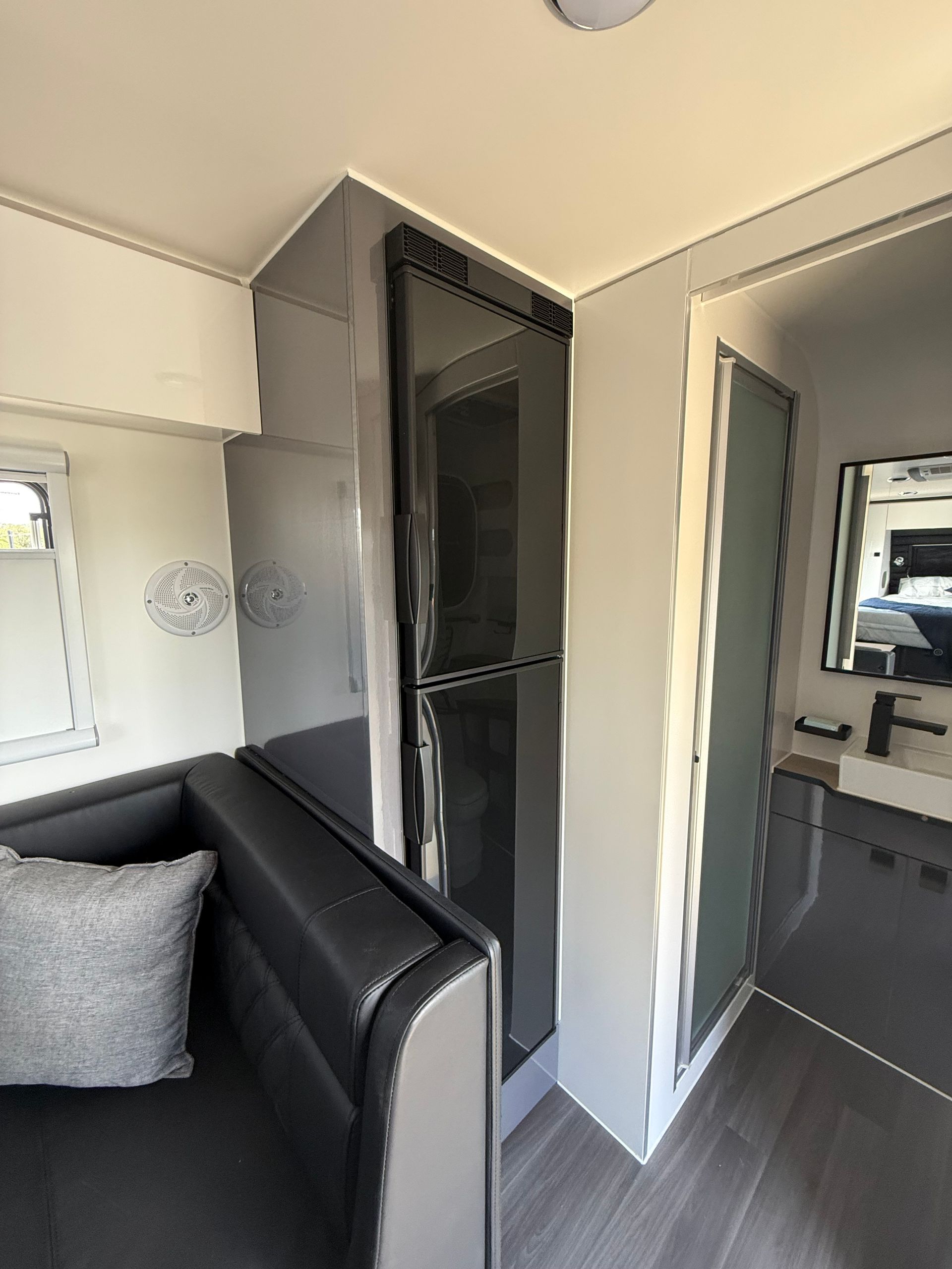 A living room with a couch and a refrigerator.