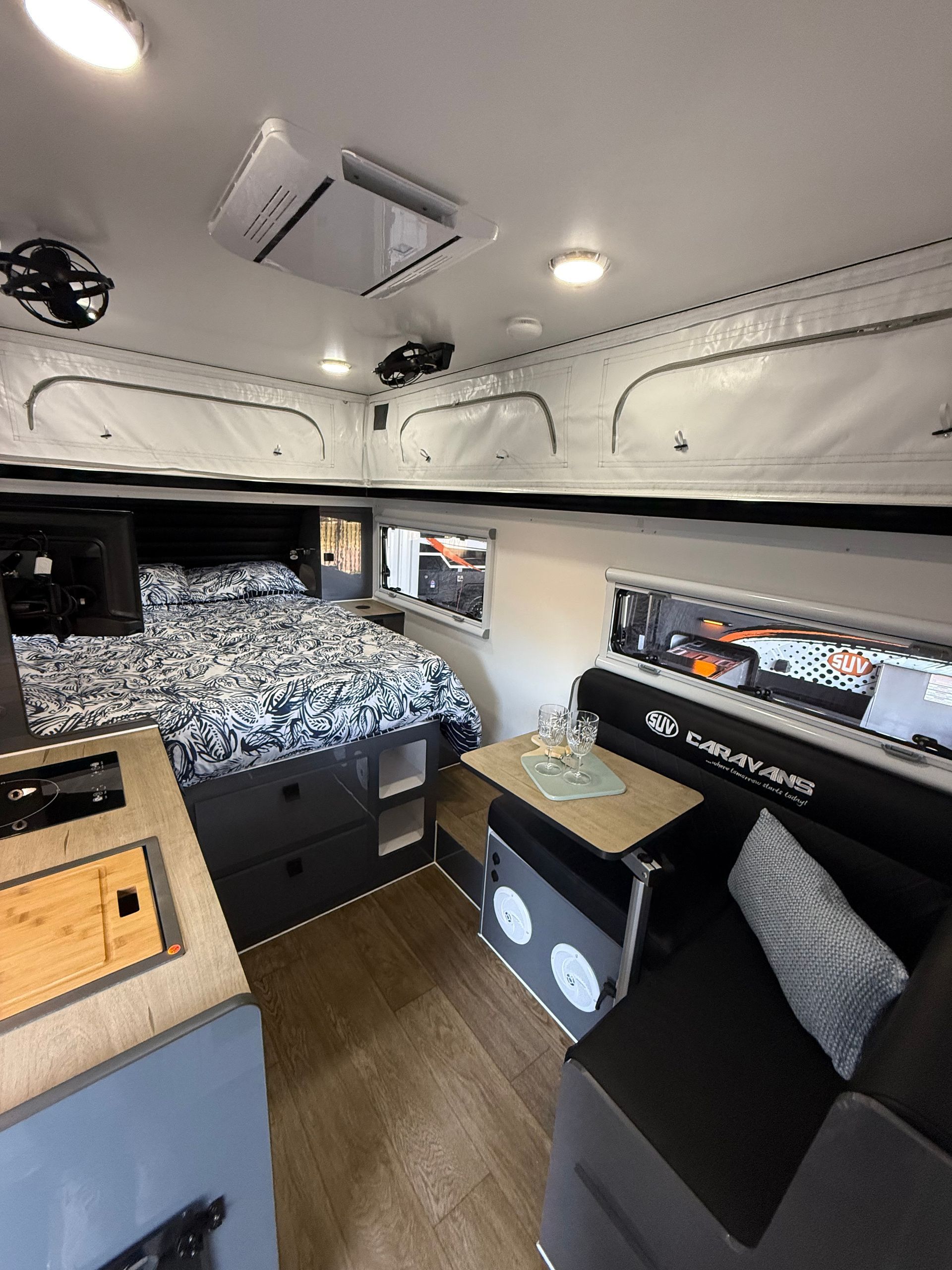 The inside of a camper with a bed , table , and couch.