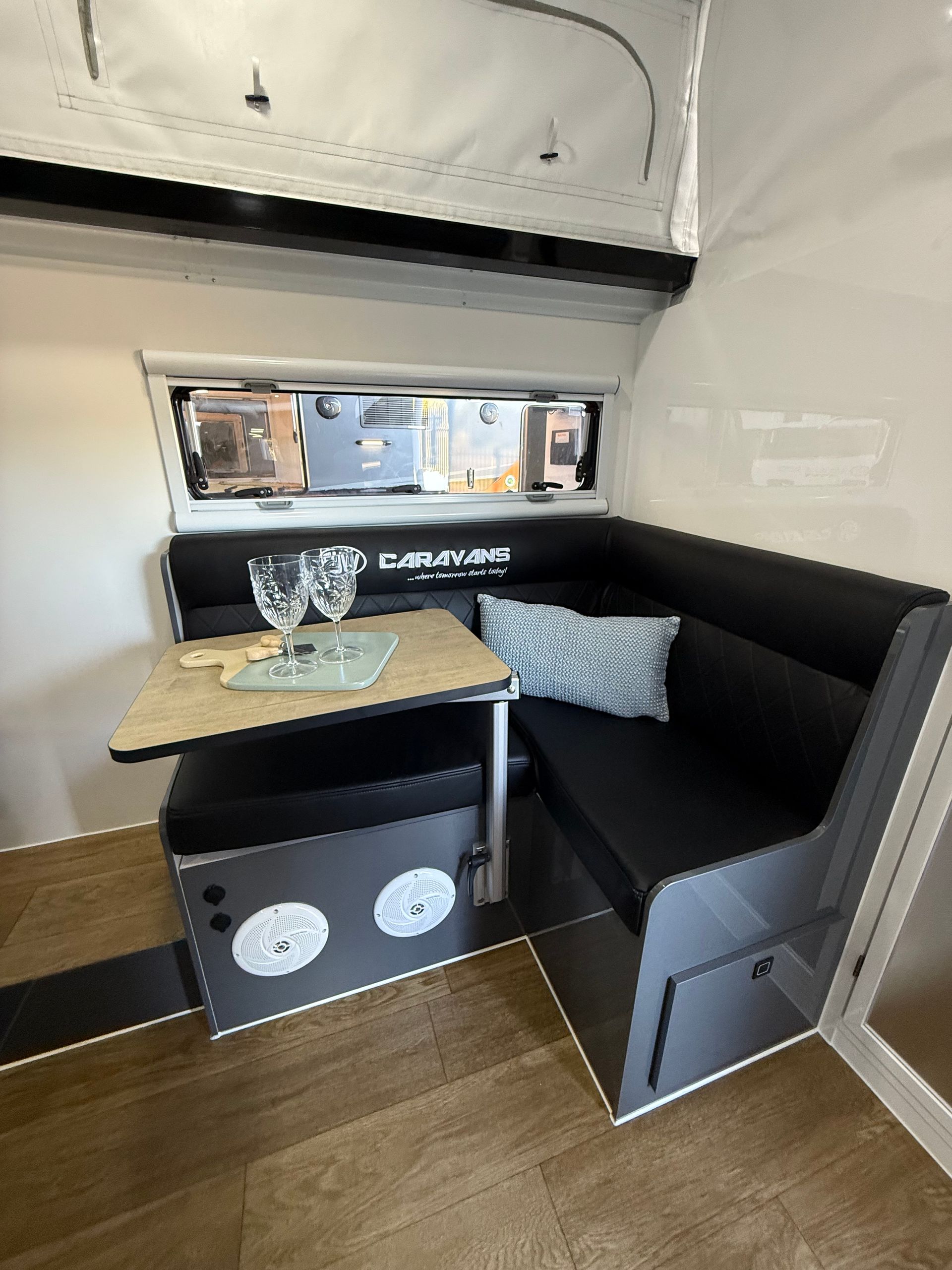 A dining room in a camper with a table and chairs.
