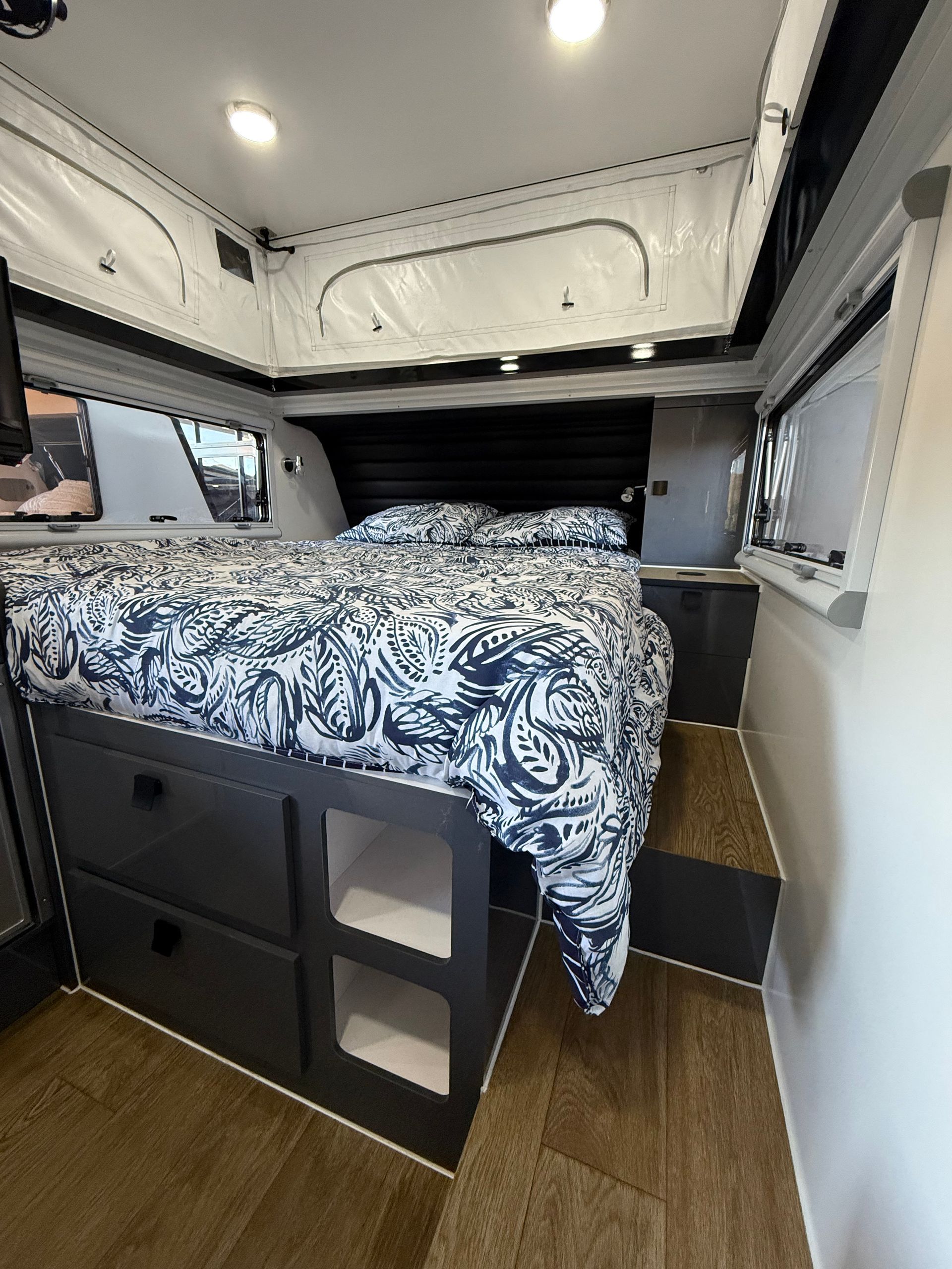 A camper van with a bed and drawers underneath it