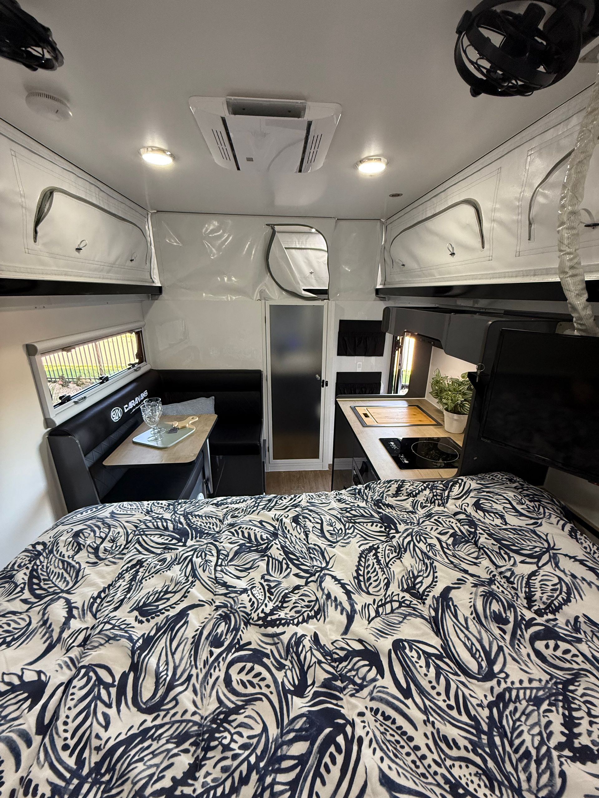 The inside of a camper with a bed and a table.