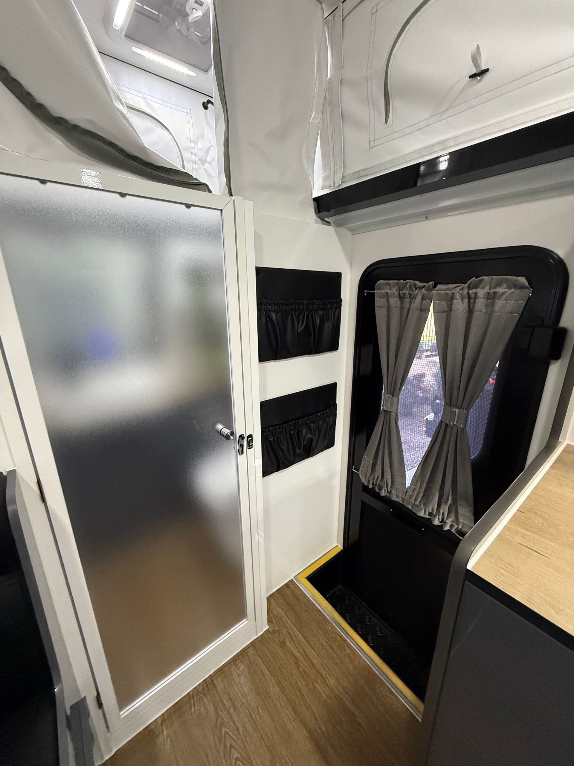 A room with a door and a window in a camper.