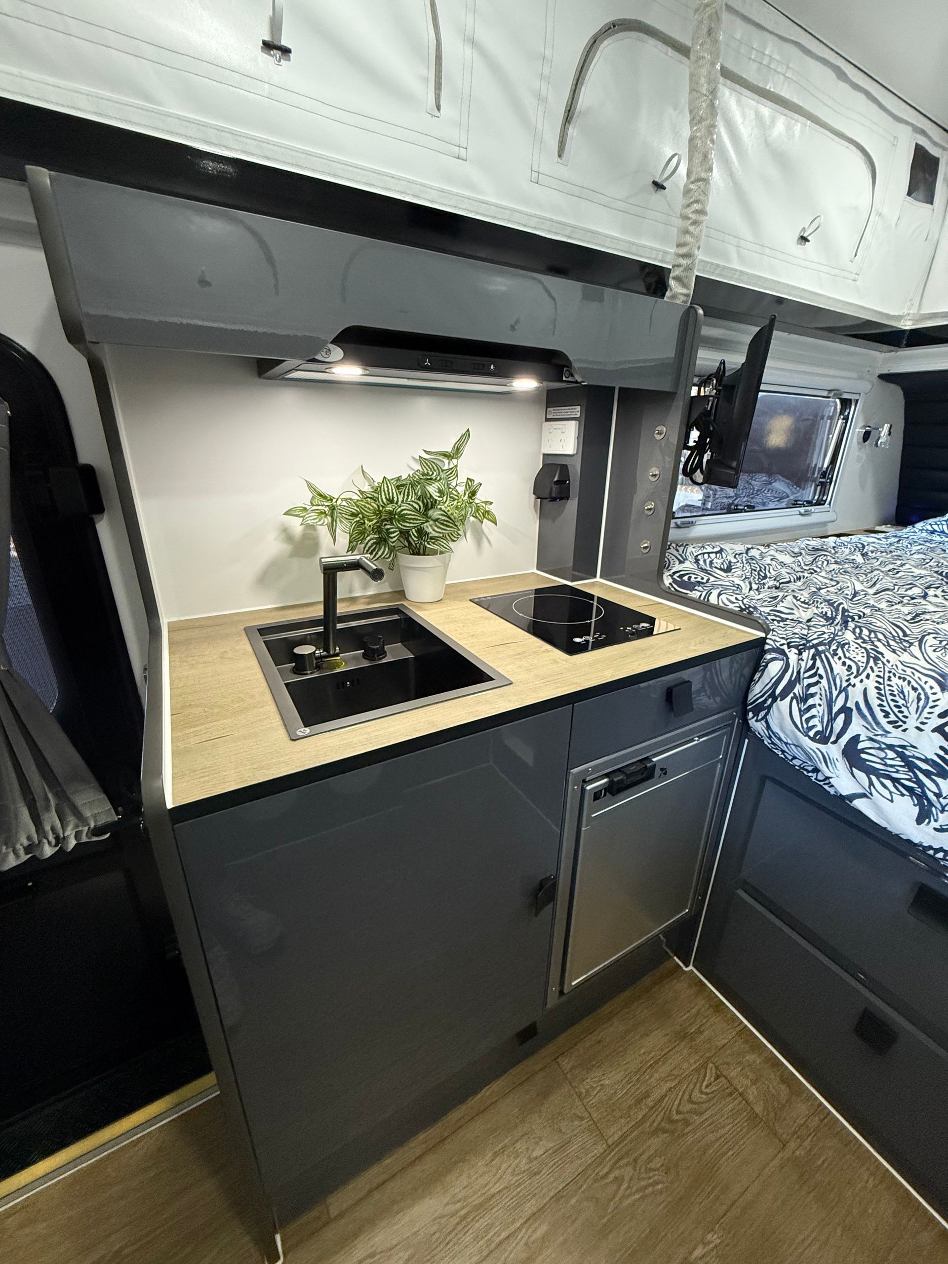 A white cabinet with drawers and a dishwasher in a camper.