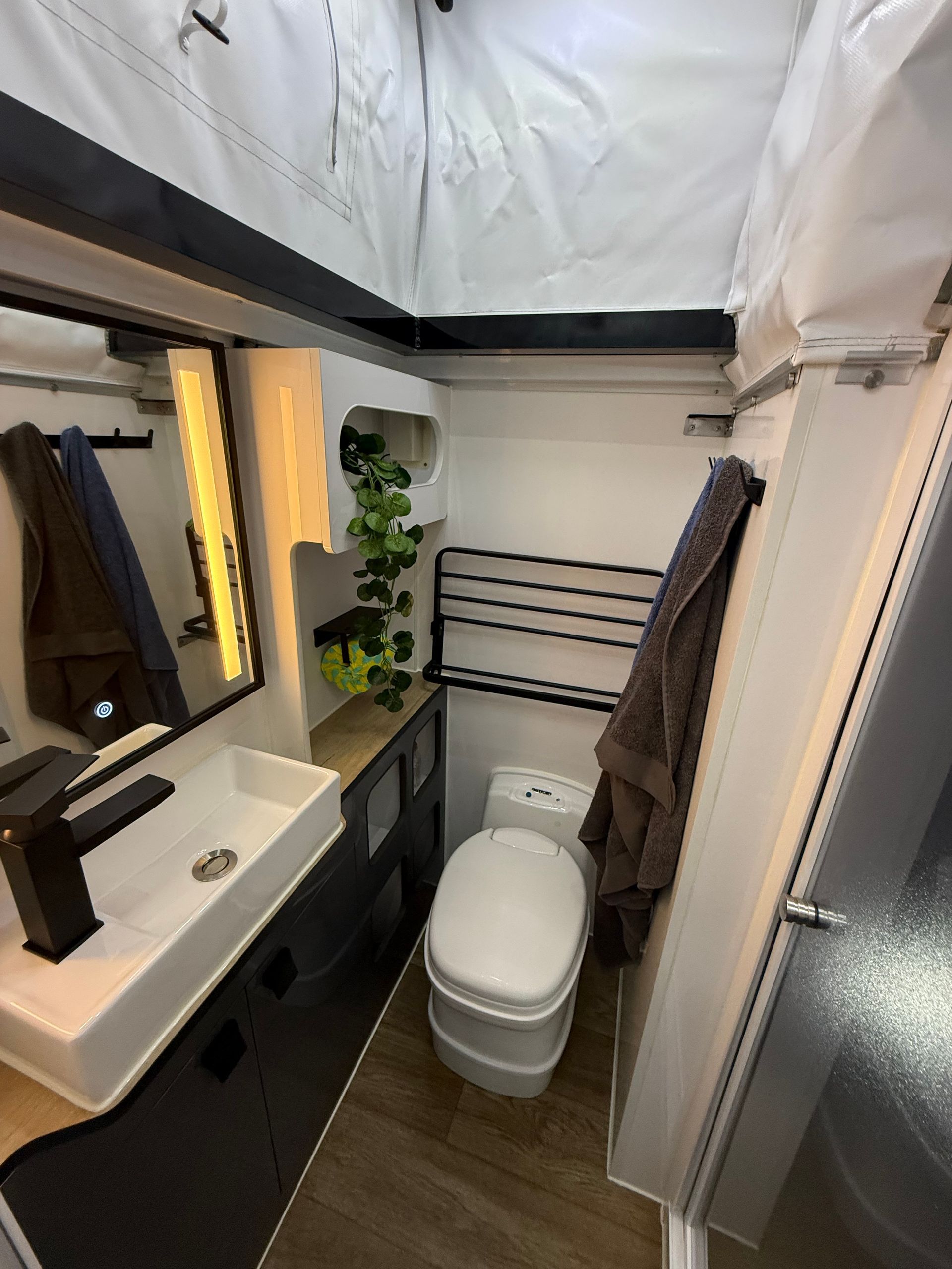 A bathroom with a toilet , sink and mirror.