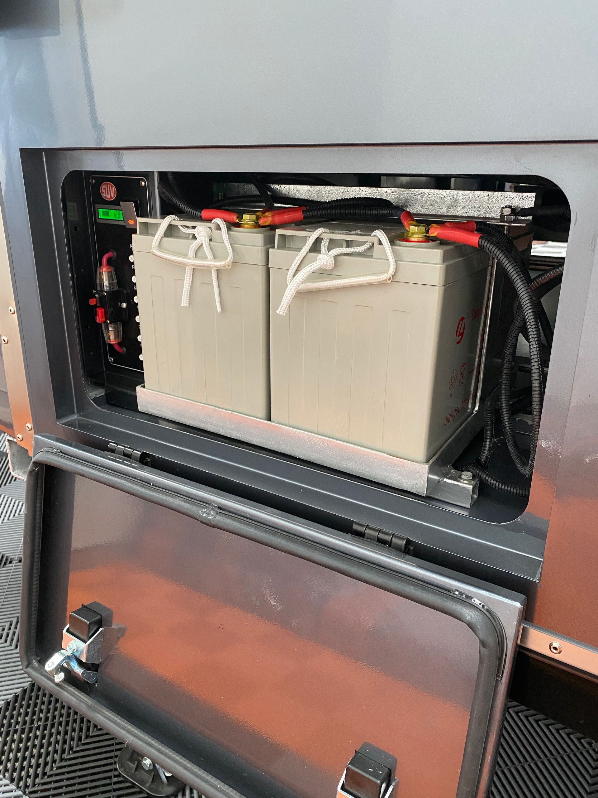 Two batteries are sitting inside of a metal box.