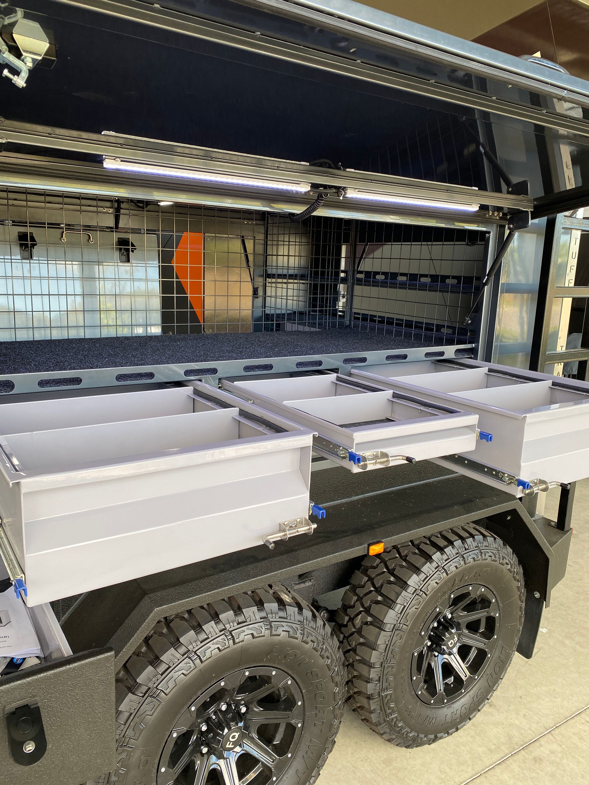 A trailer with a lot of drawers on it is parked in a garage.
