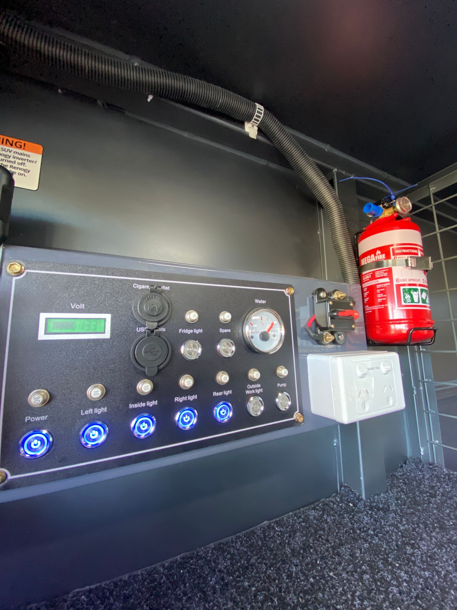 A fire extinguisher is sitting on top of a control panel.