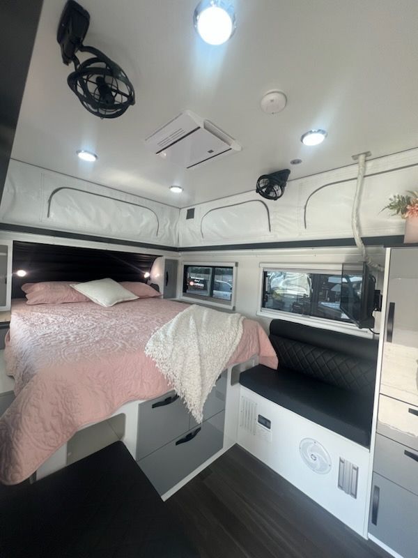 A bedroom with a bed and a fan on the ceiling