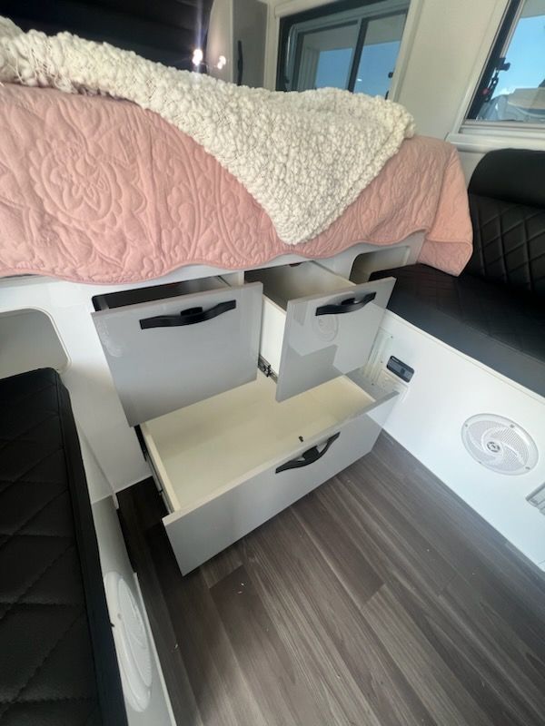 A bedroom with a bed and drawers underneath it.