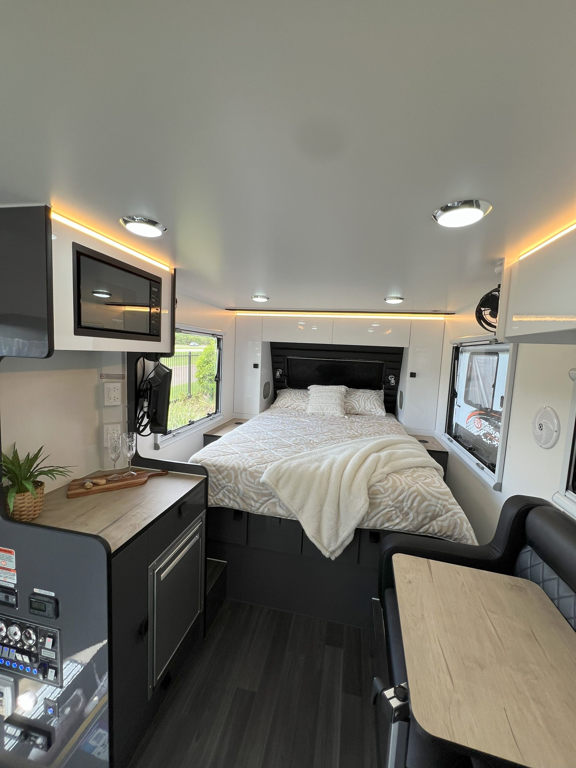 The inside of a camper with a bed and a table.