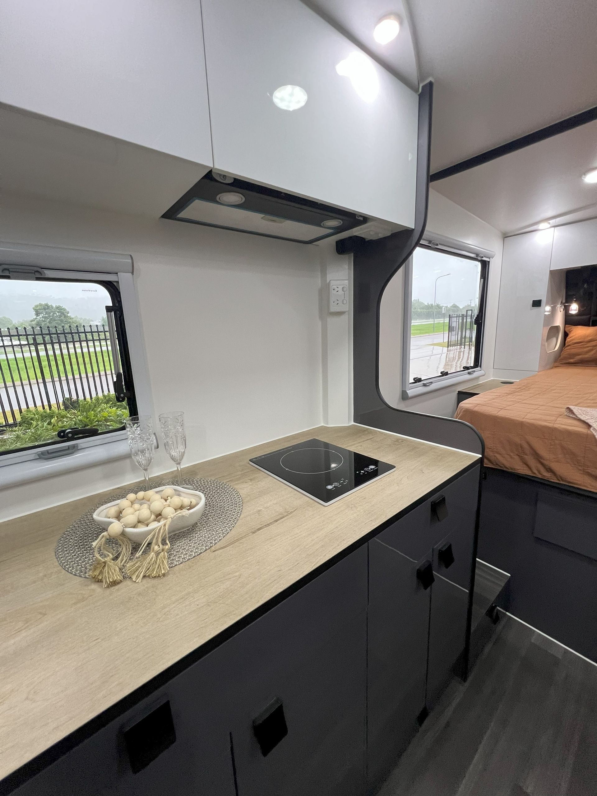 A kitchen in a camper van with a stove and a bed.