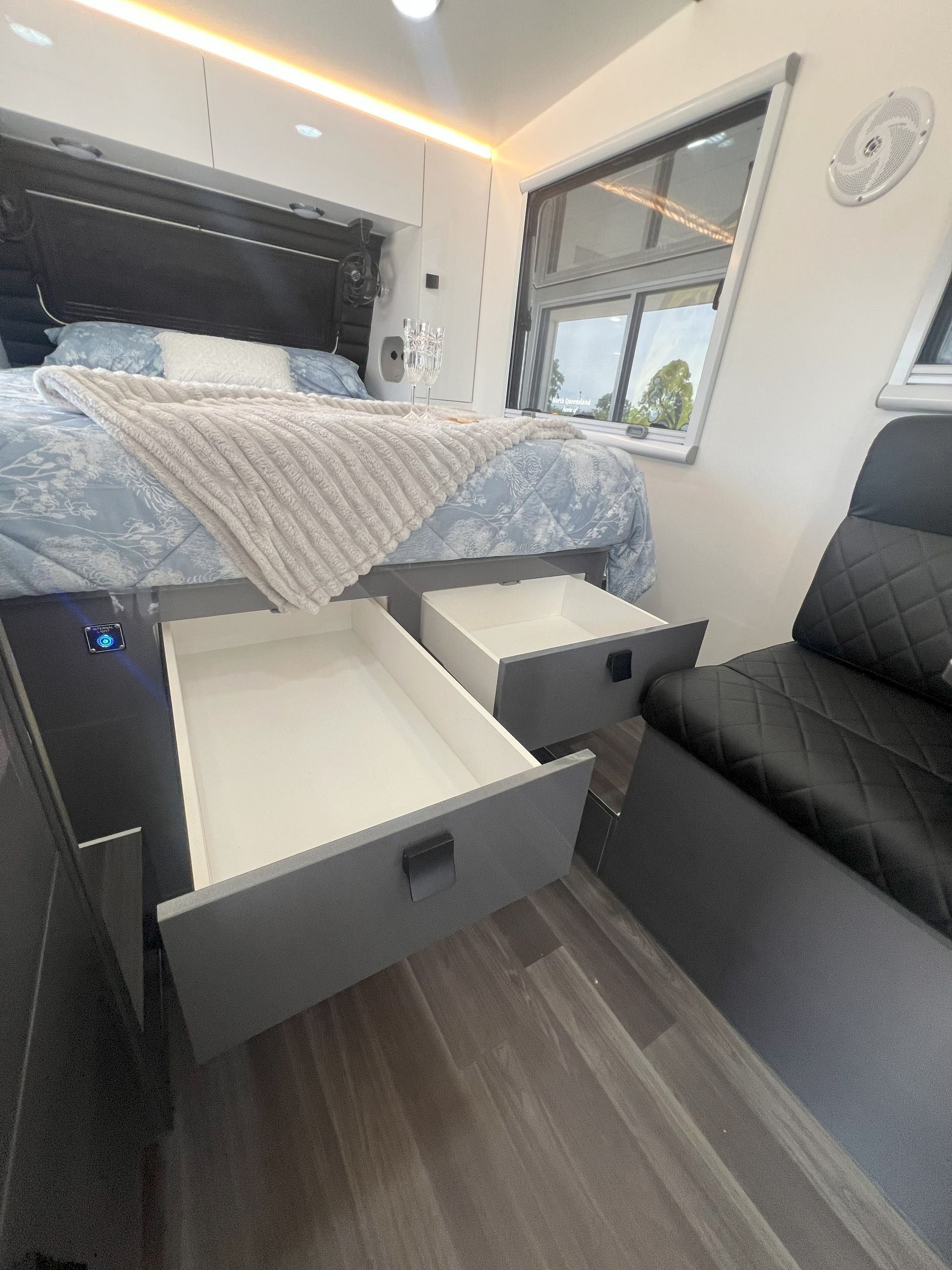 A bedroom with a bed and two drawers open.