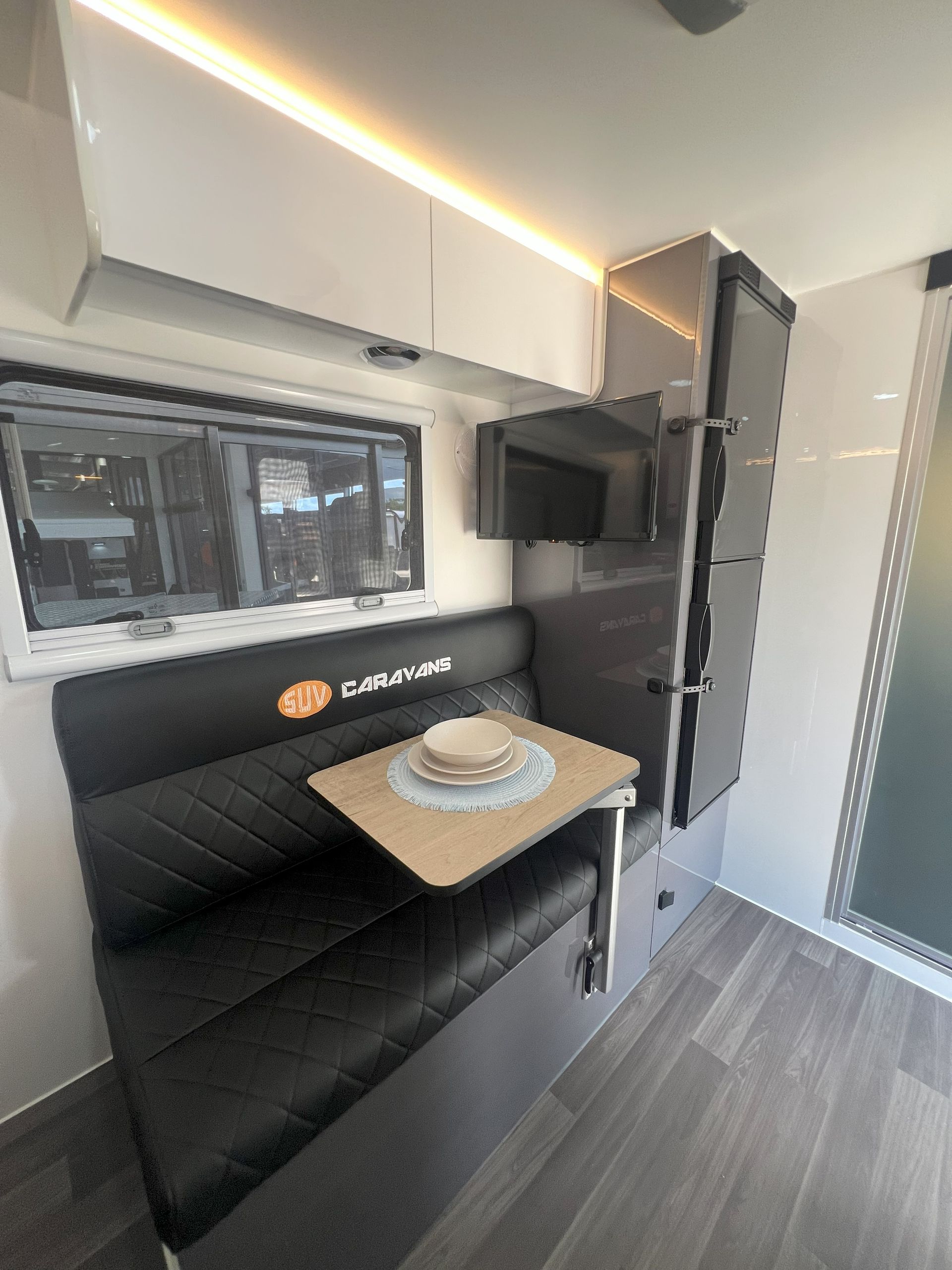 A rv with a table and a couch in it.