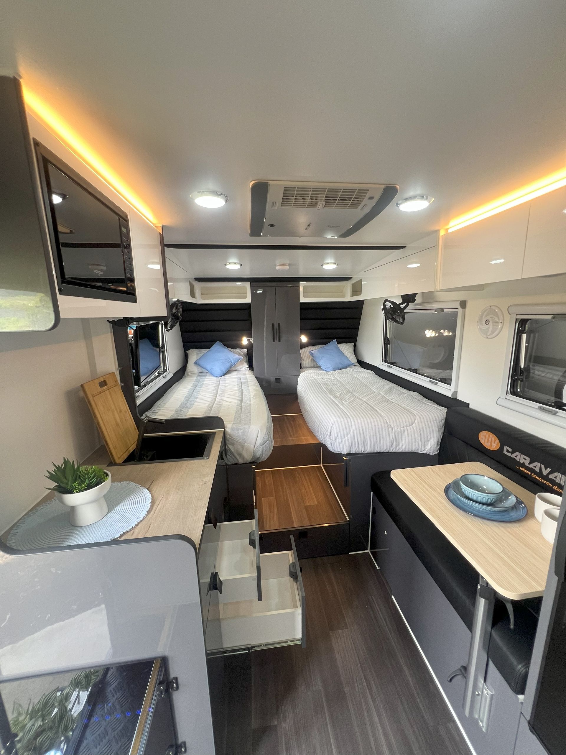 The inside of a camper van with two beds and a table.