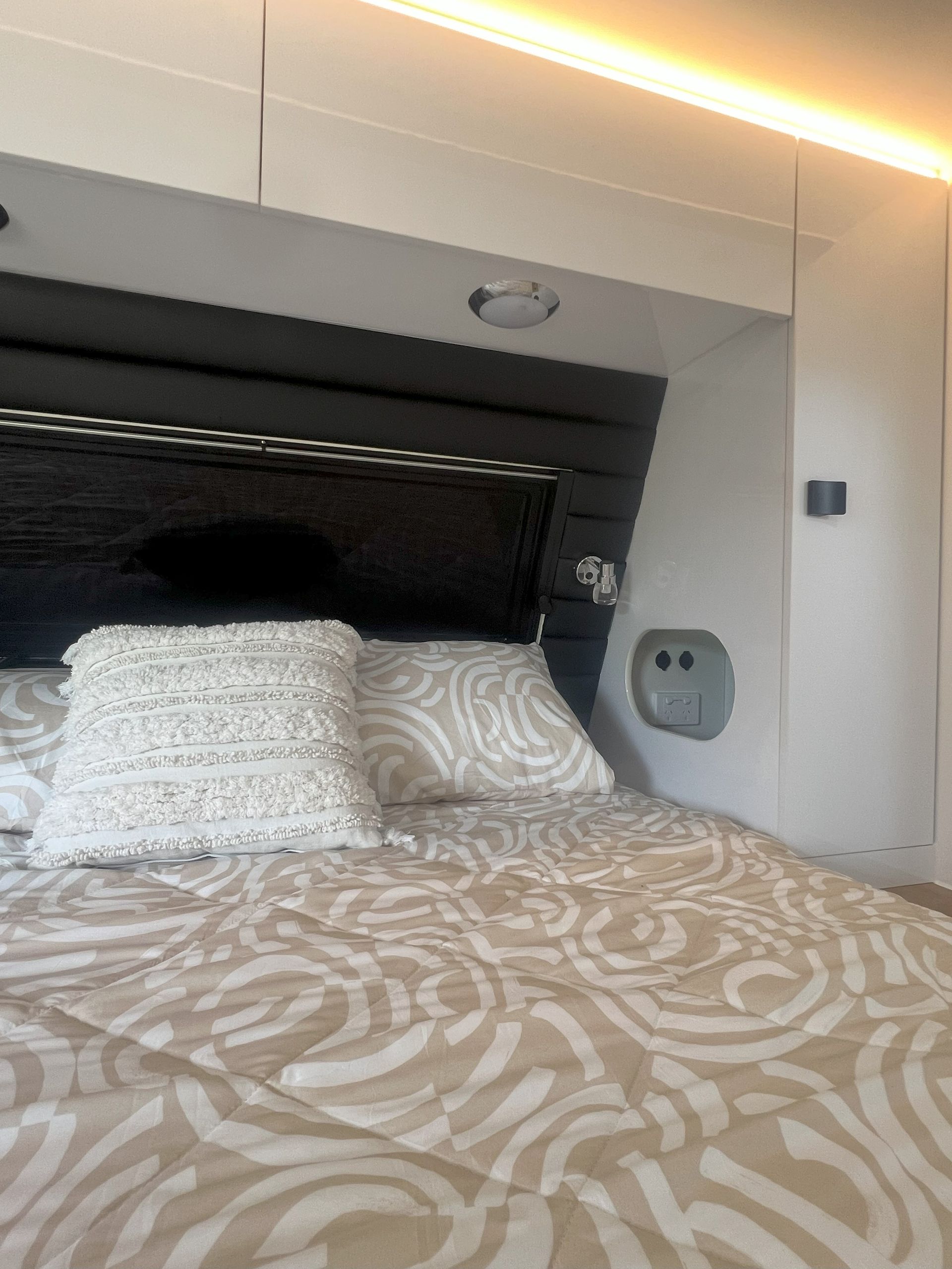 A bed with a patterned blanket and pillows in a room.