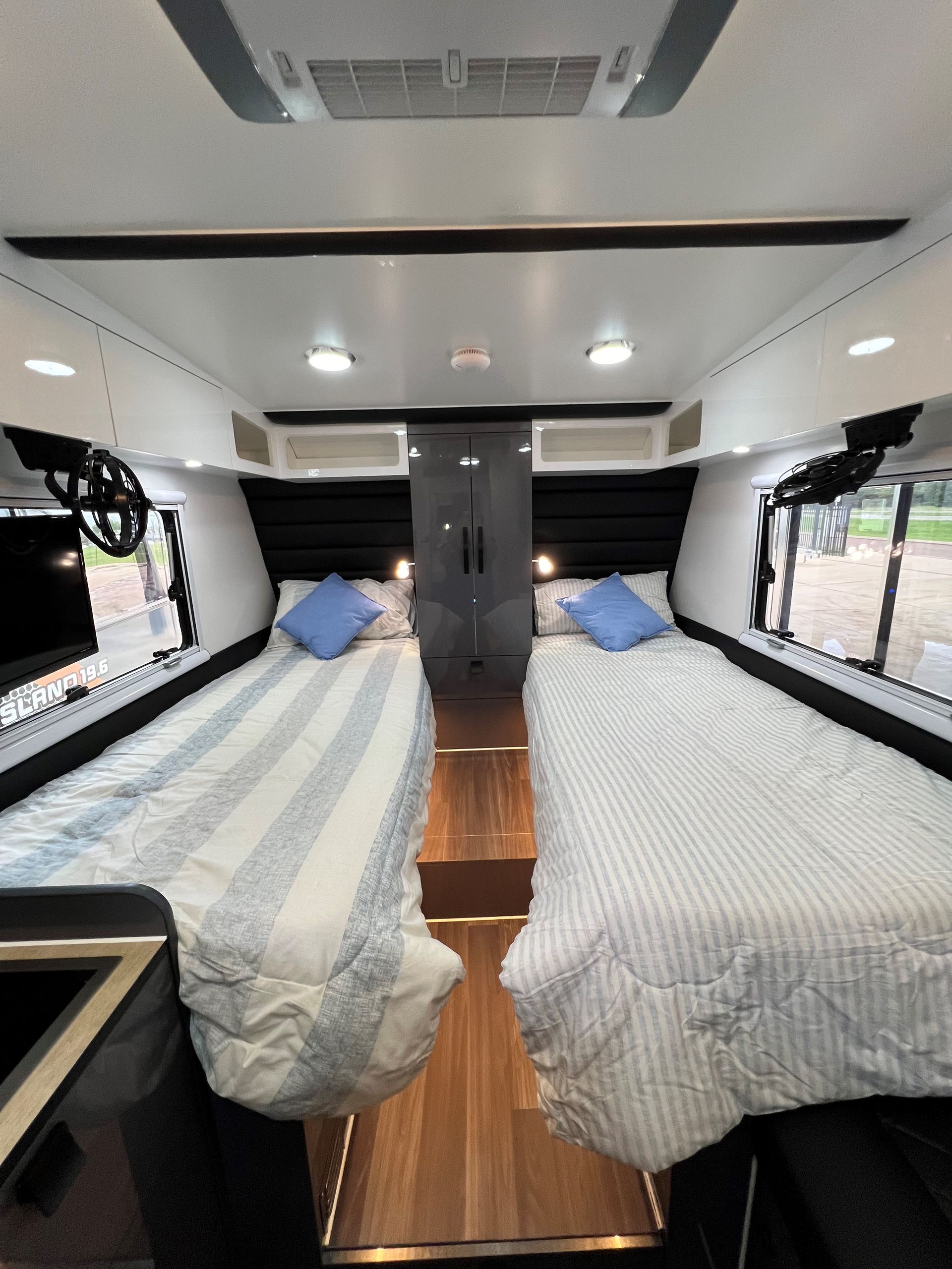 The inside of a camper van with two beds and a television.