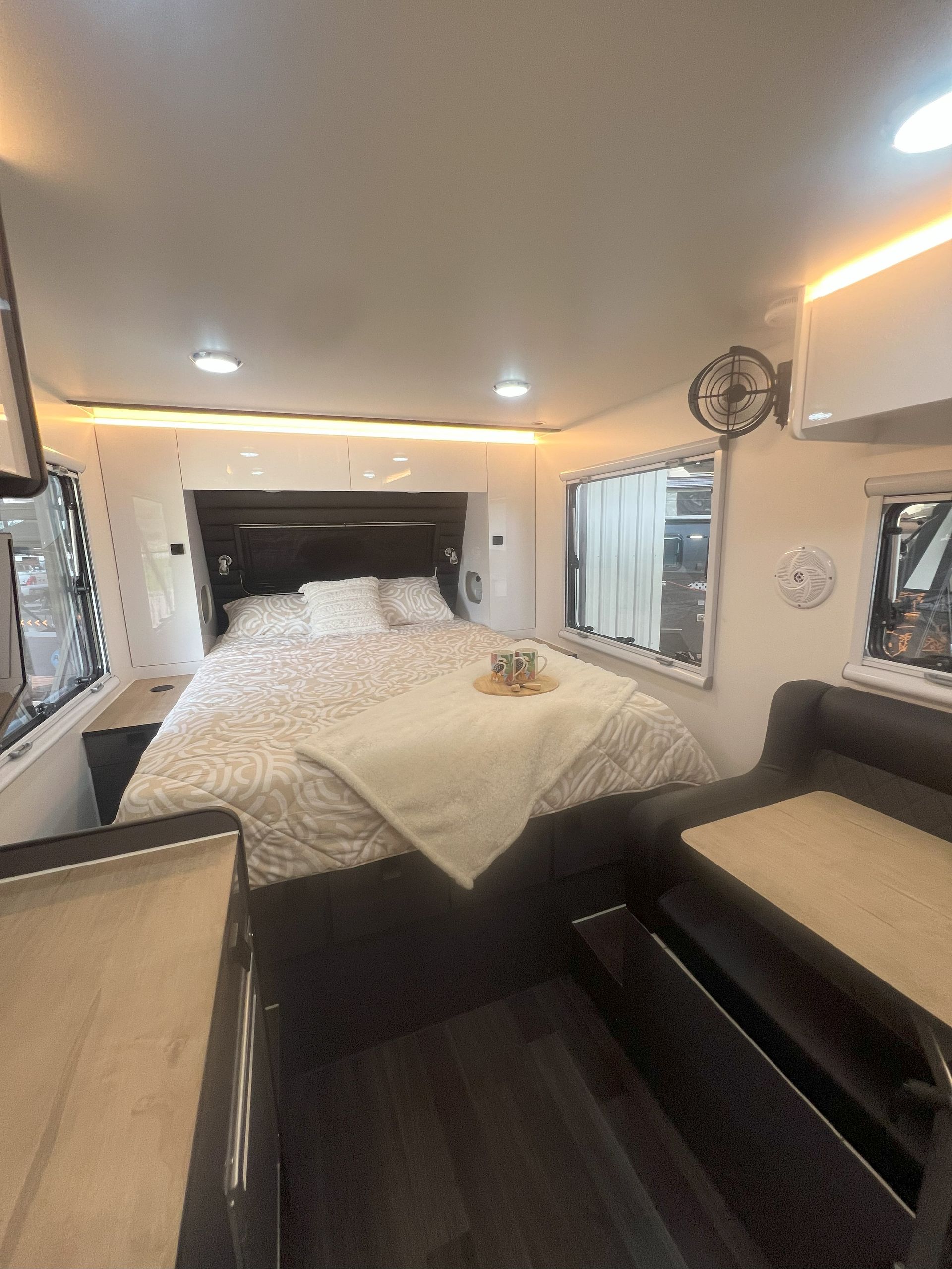 A bedroom in a camper with a bed and a couch.