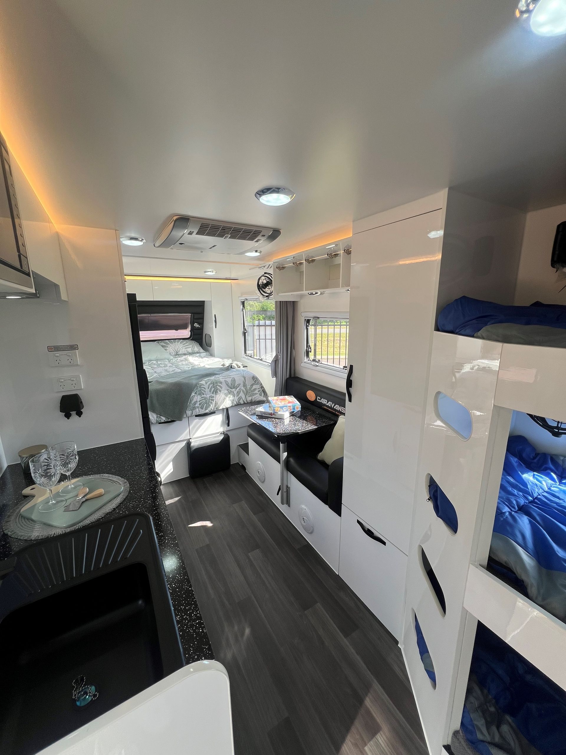The inside of a camper with bunk beds and a sink.