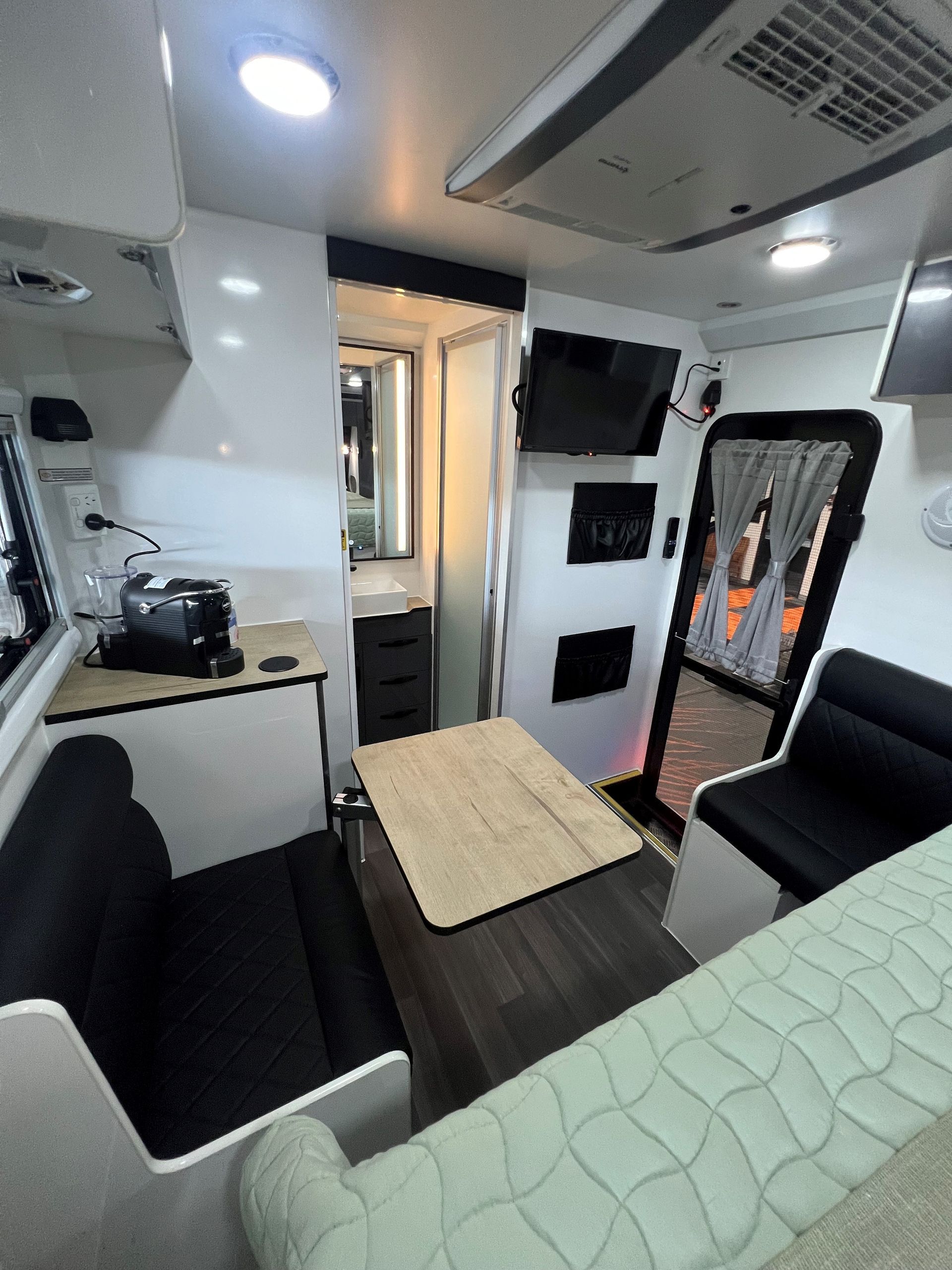 A living room with a couch , table , chairs and a television.