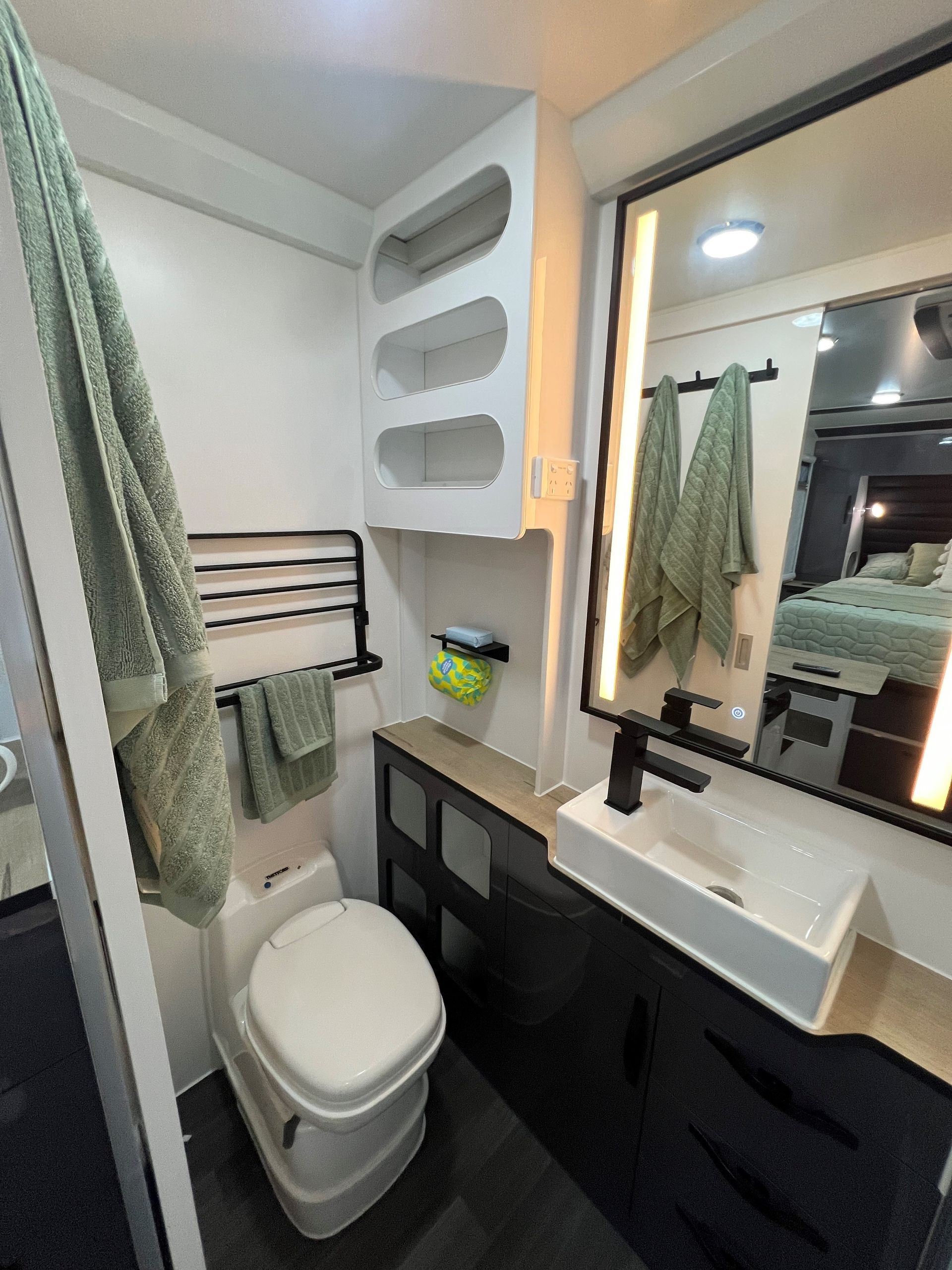 A bathroom with a toilet , sink and mirror.