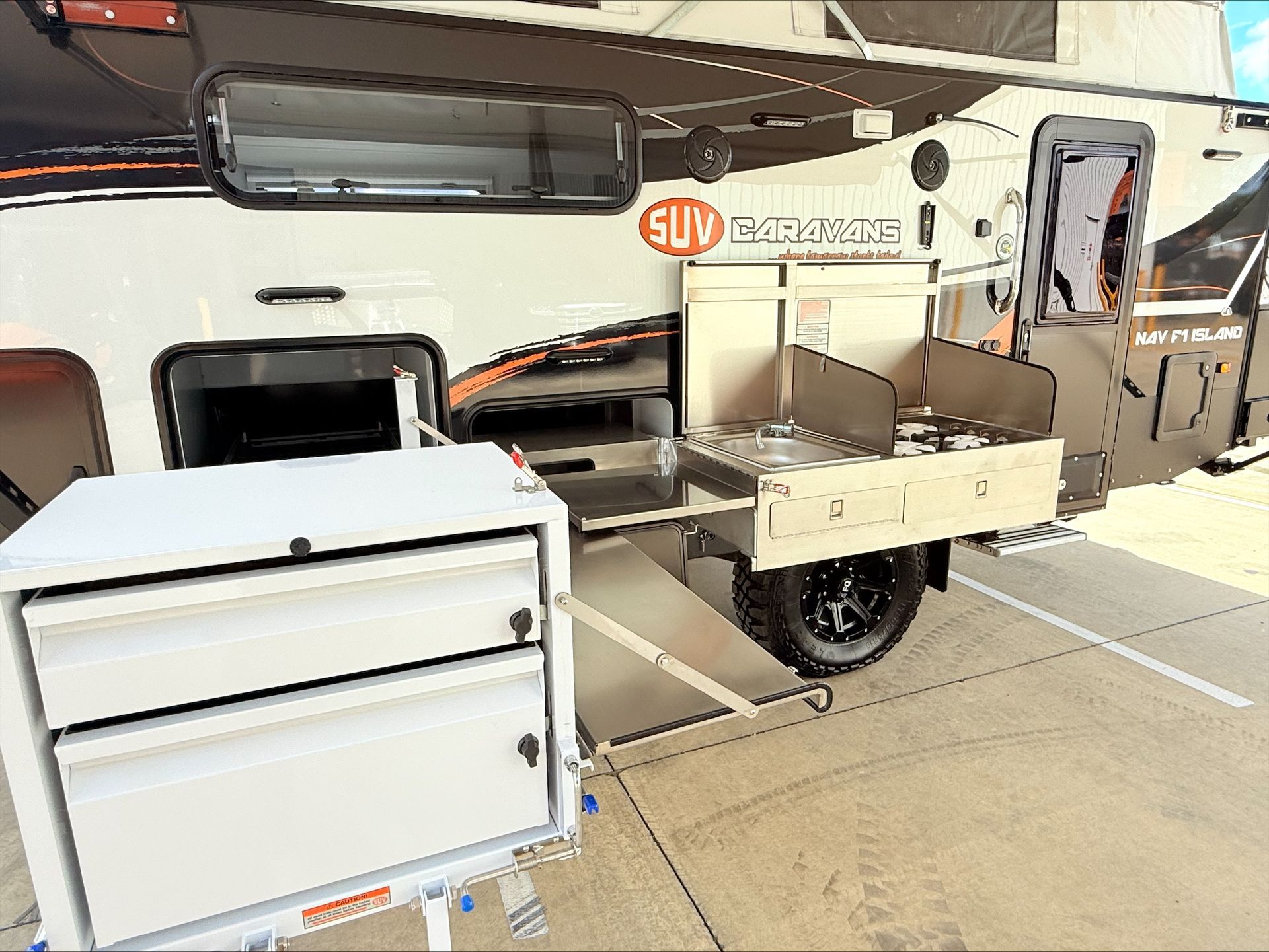 A trailer with a kitchen attached to it is parked in a parking lot.