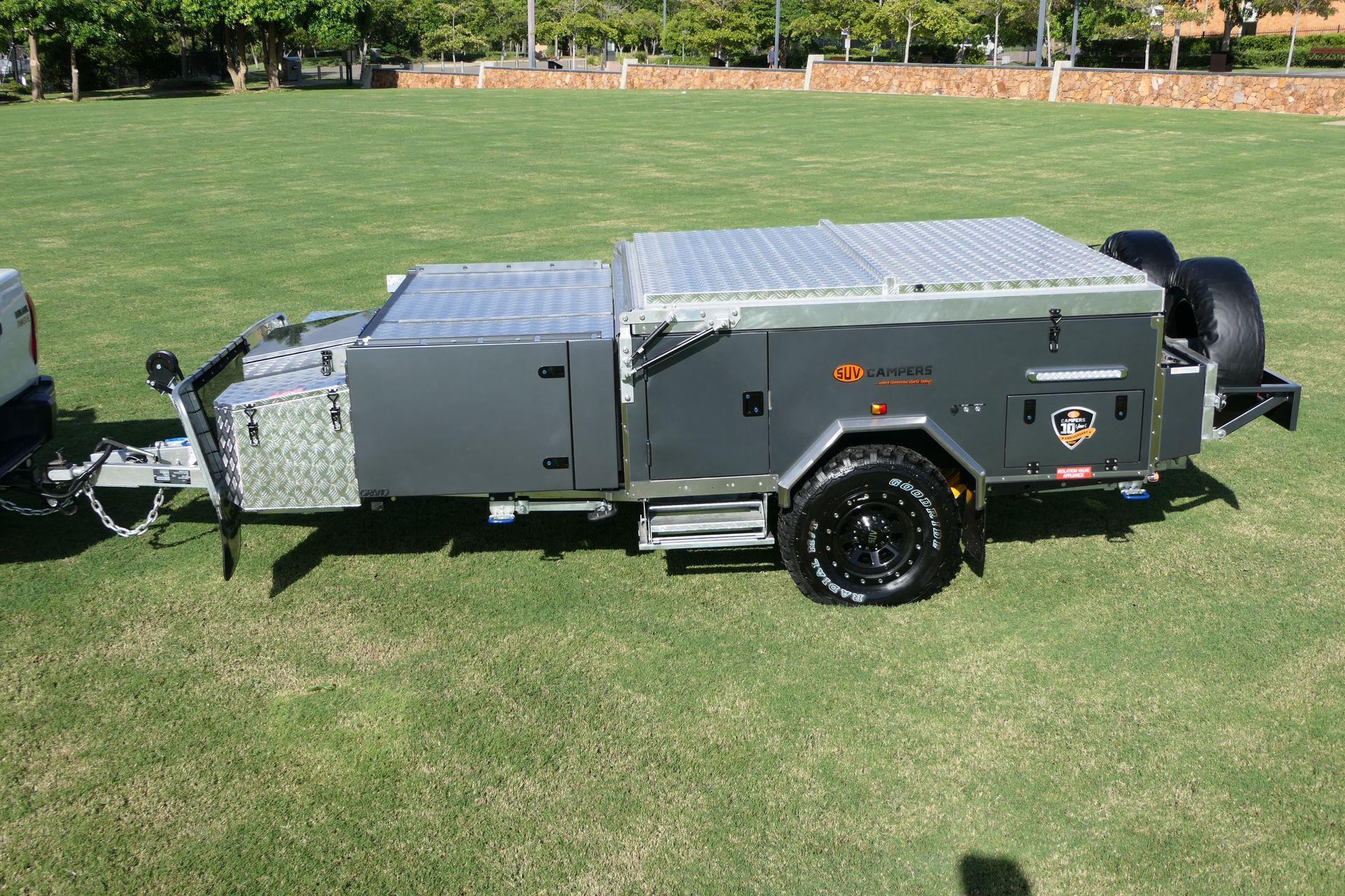 A trailer is parked on a lush green field.