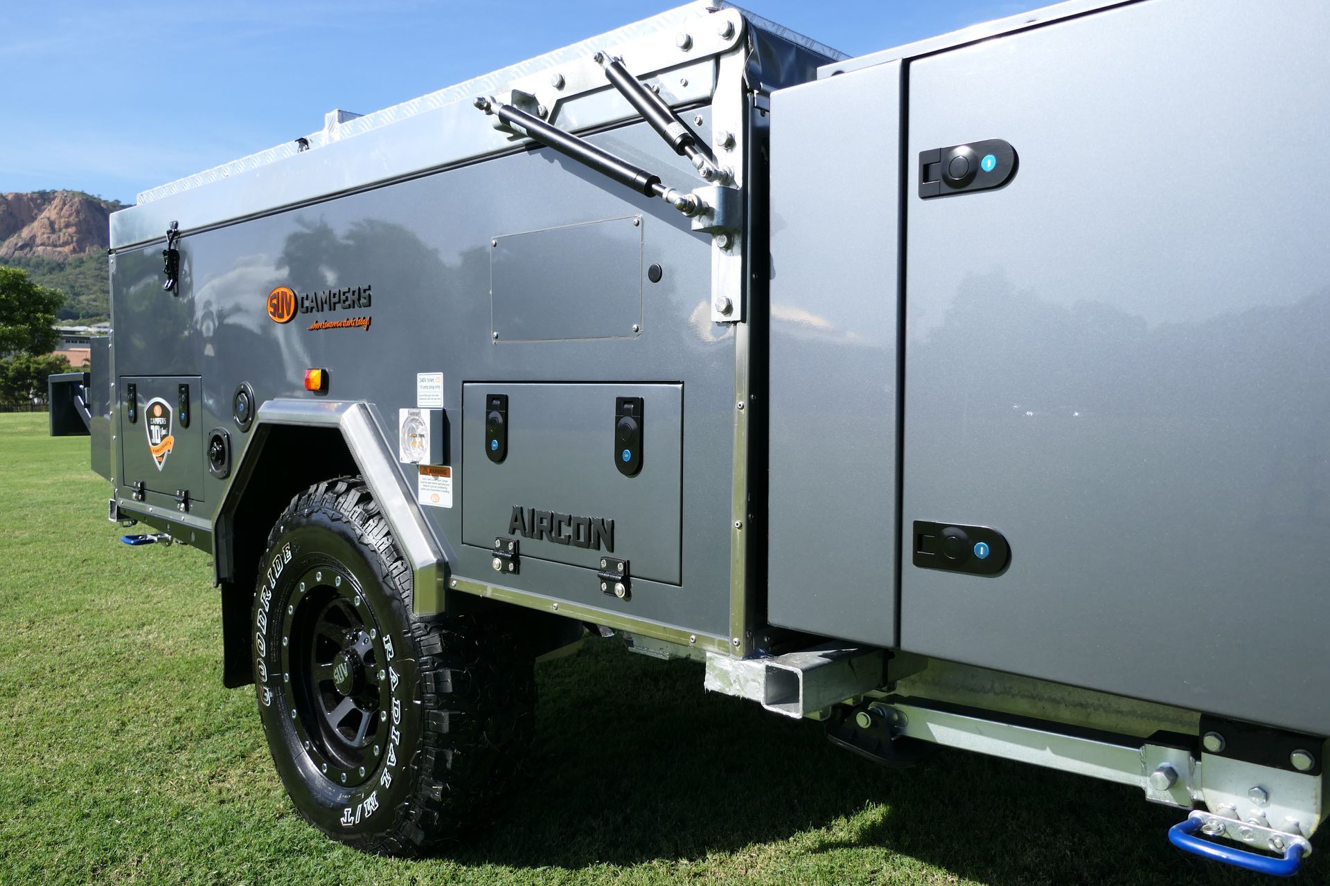 A camper trailer is parked in a grassy field.
