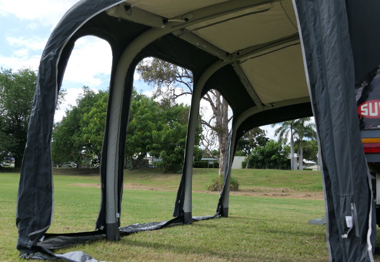 A tent is sitting on top of a lush green field.